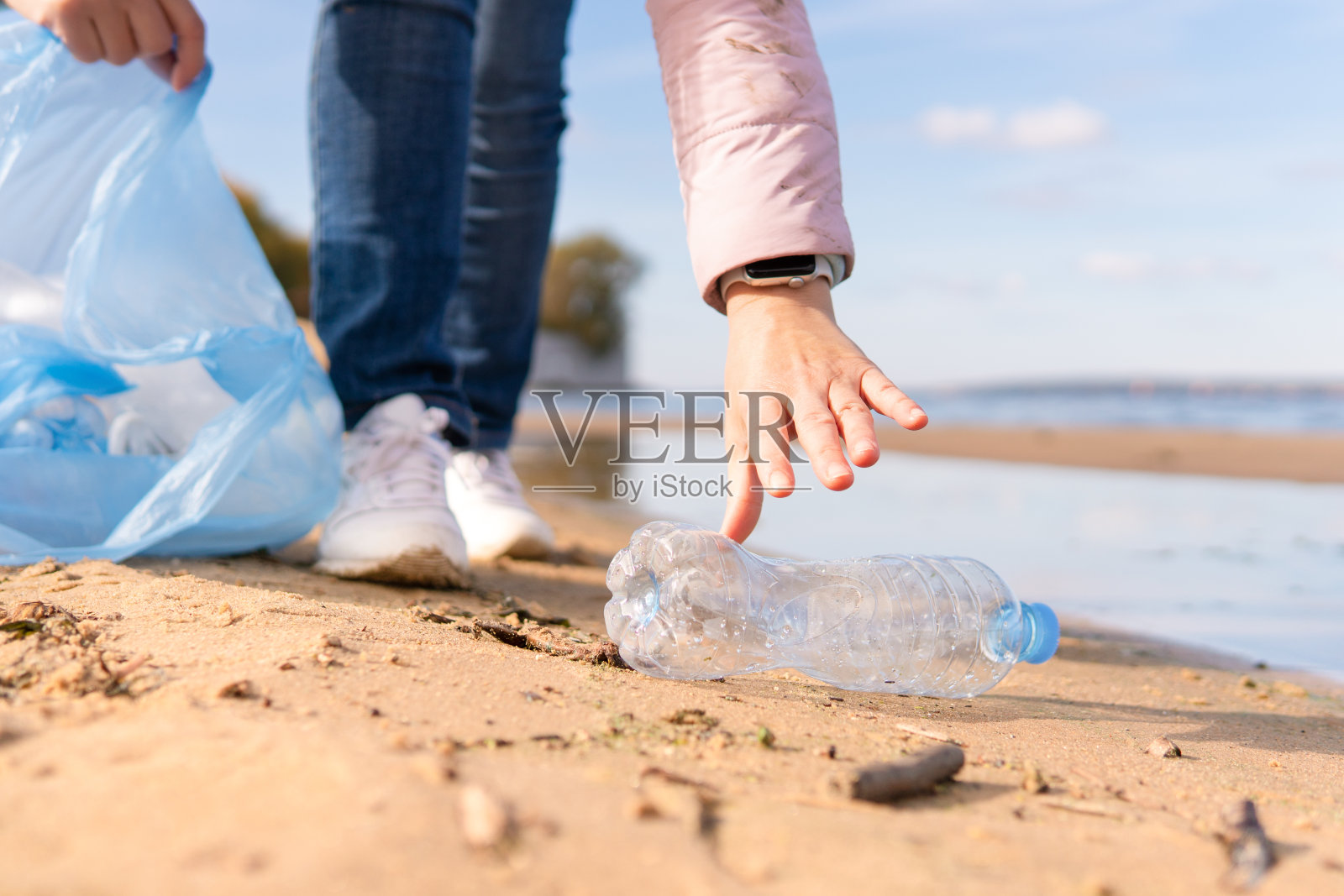 一名女性志愿者正在清理大自然中的塑料垃圾。照片摄影图片