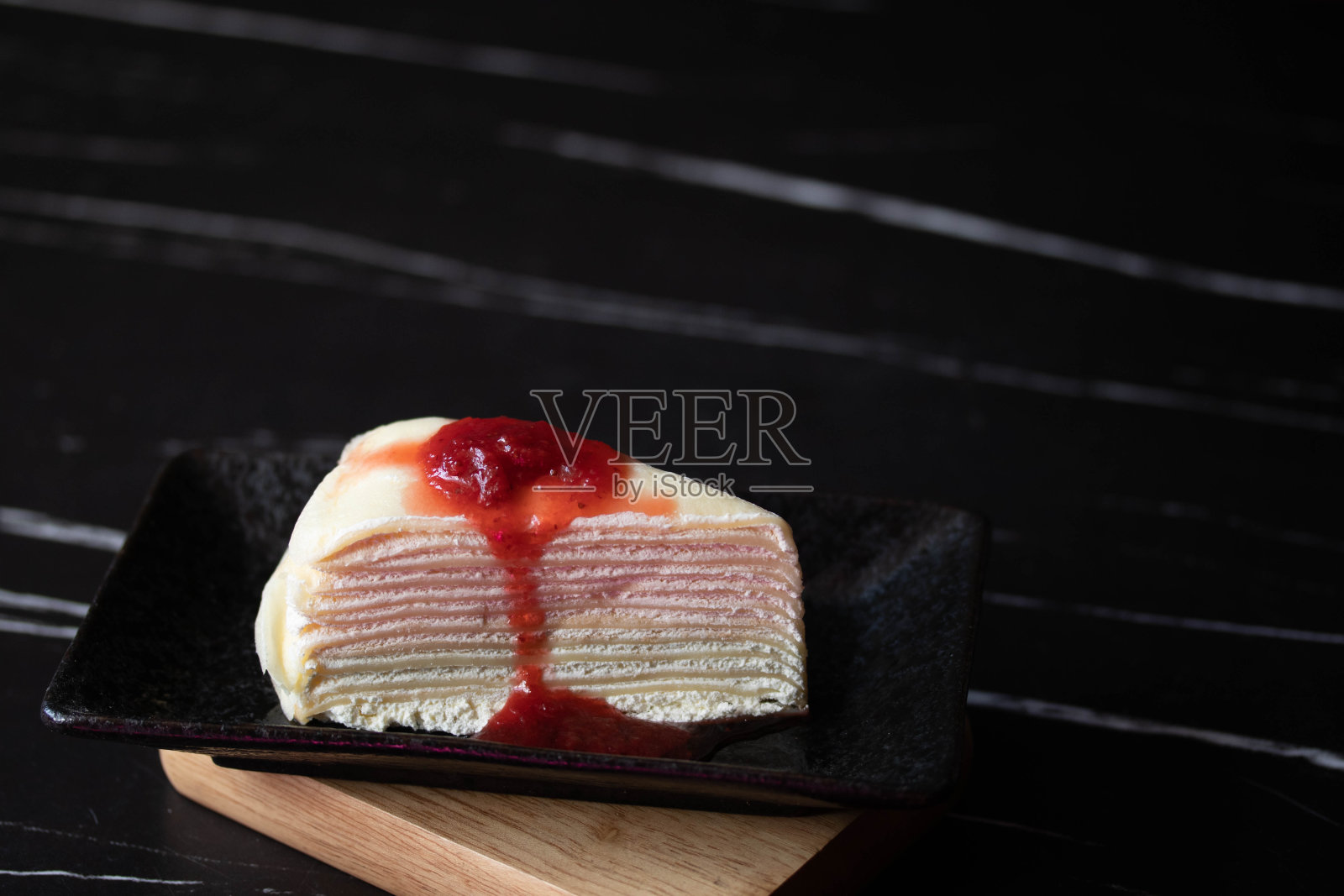 草莓可丽饼分层呈黑色。照片摄影图片