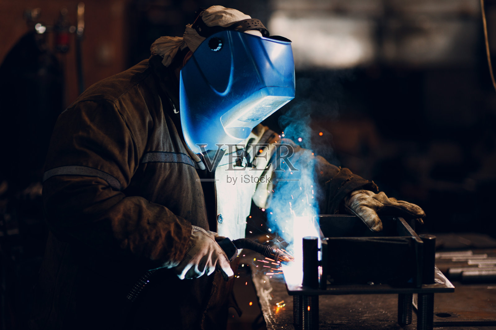 焊工在工厂内焊接金属、钢、工业部件照片摄影图片