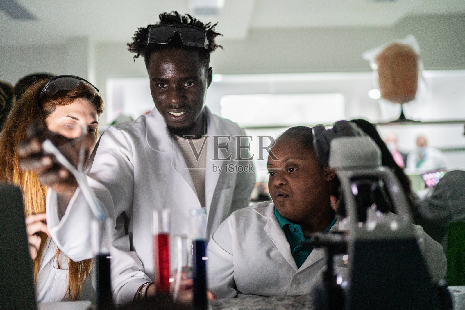 学生们在实验室里做一个实验——包括有特殊需求的人照片摄影图片