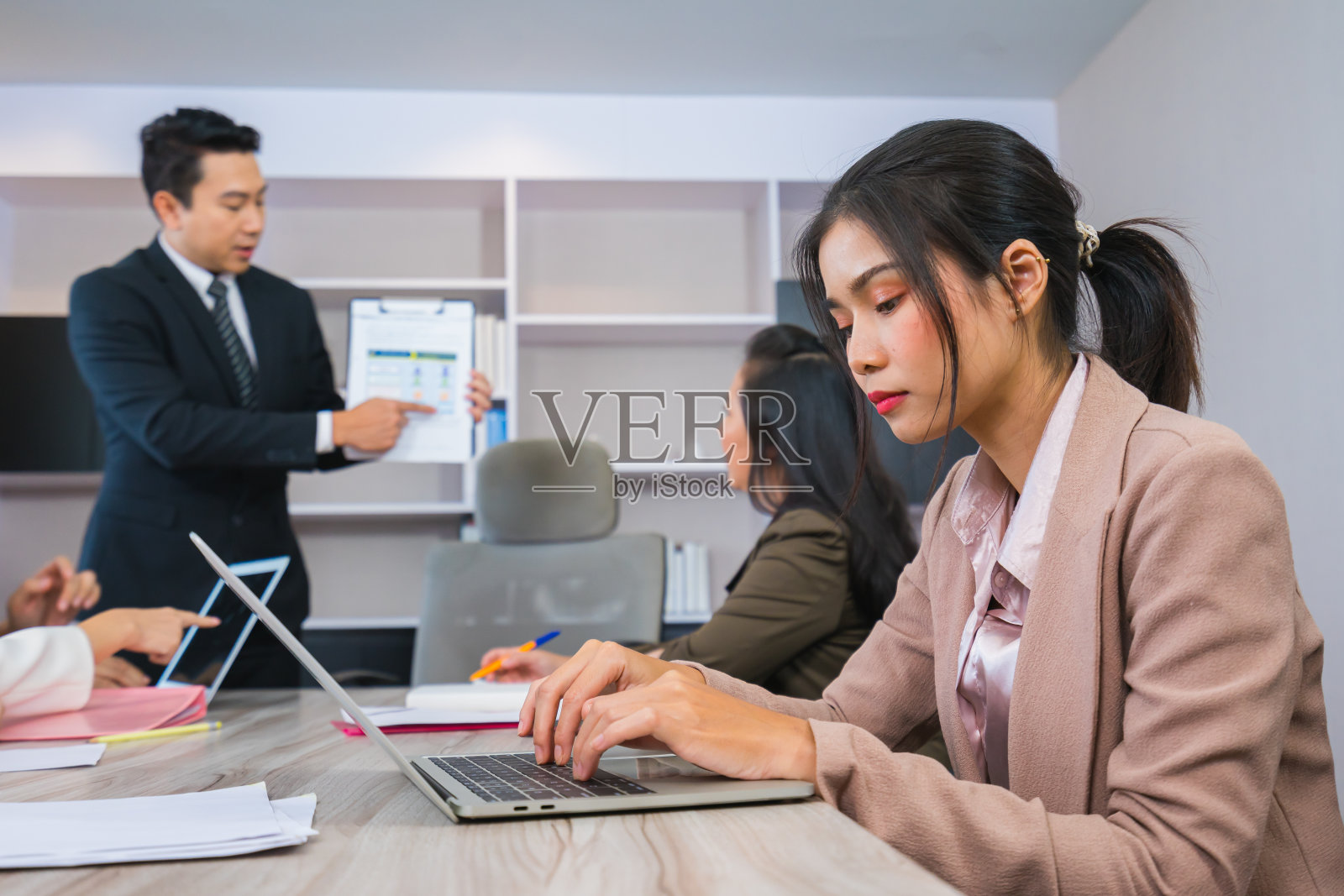 年轻女性在专业团队会议上使用笔记本电脑照片摄影图片