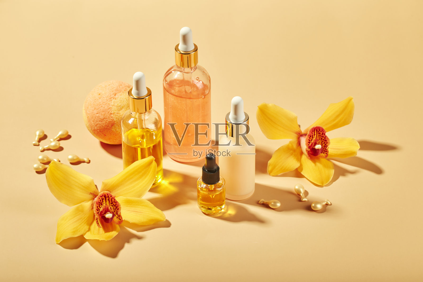 装有兰花花的玻璃瓶中的化妆品-精华液，乳霜，凝胶，油。概念面部和身体护理，健康和水疗，热带放松。照片摄影图片