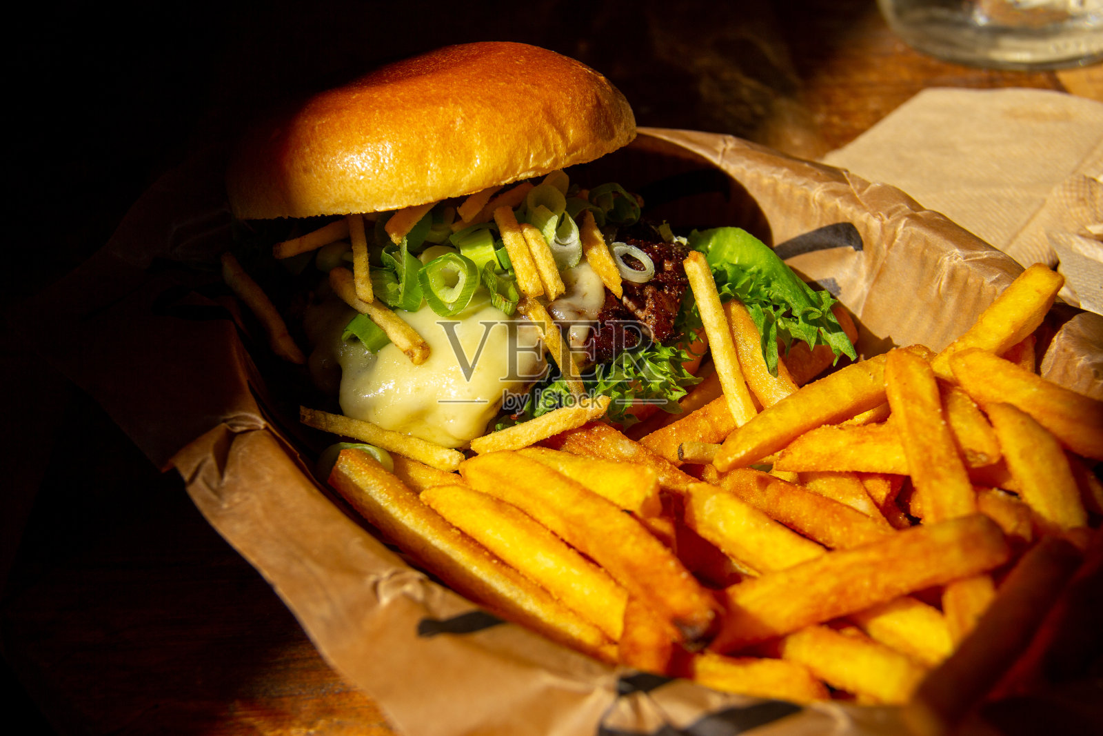 芝士汉堡和薯条放在桌子上照片摄影图片