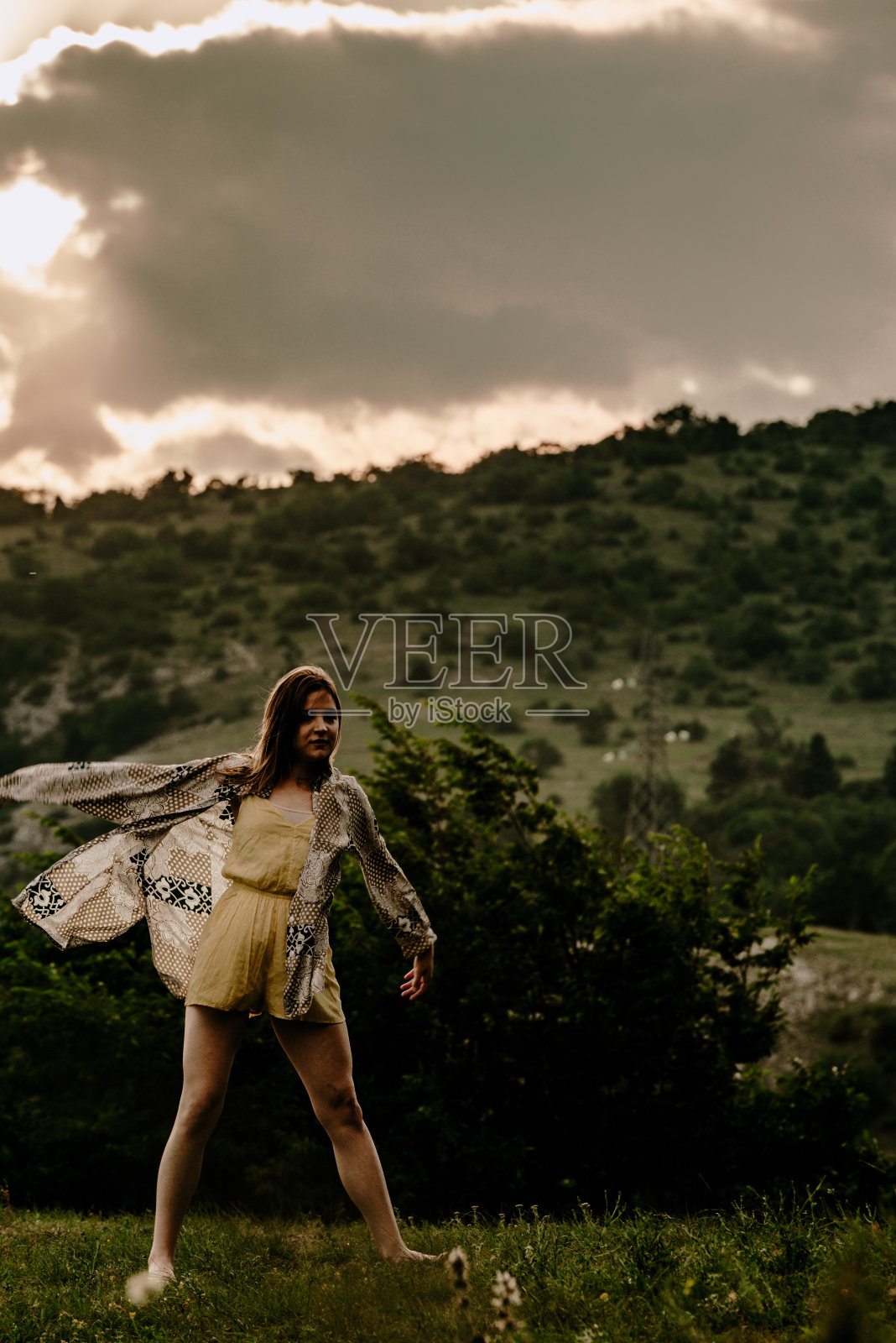 一个女人的剪影，在夕阳下的天空中跳跃照片摄影图片