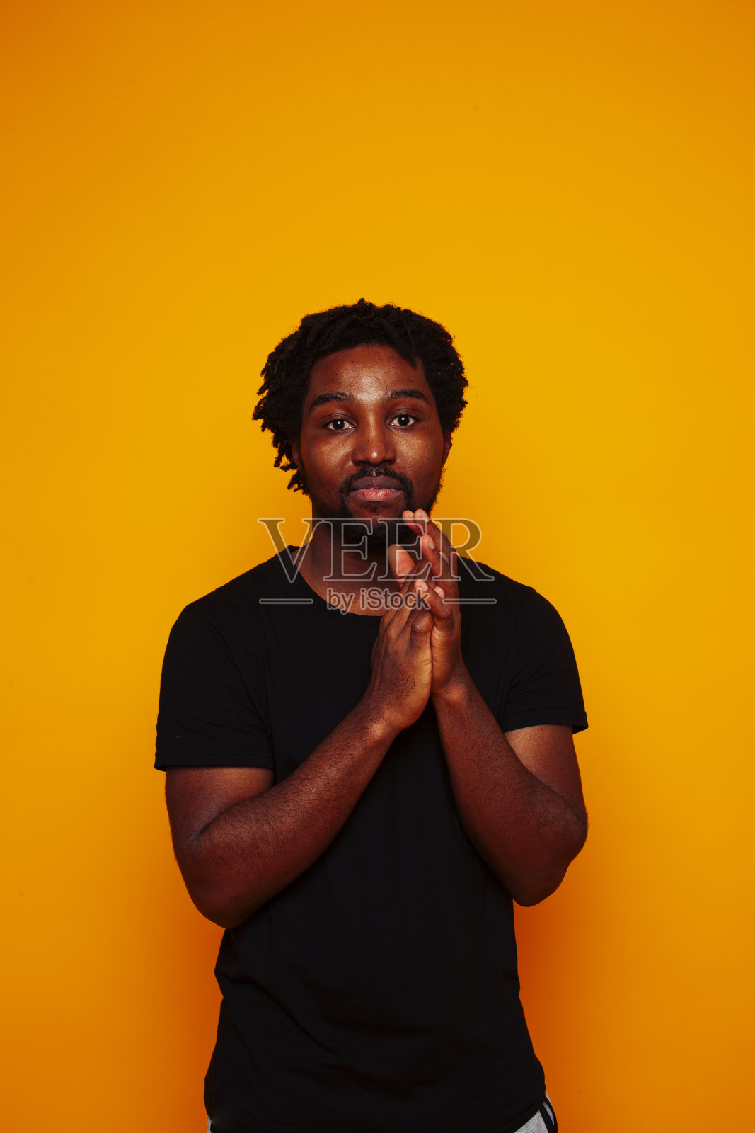 年轻英俊的非洲裔美国男学生欢快地摆姿势，在黄色的背景上打手势，生活方式的人的概念照片摄影图片