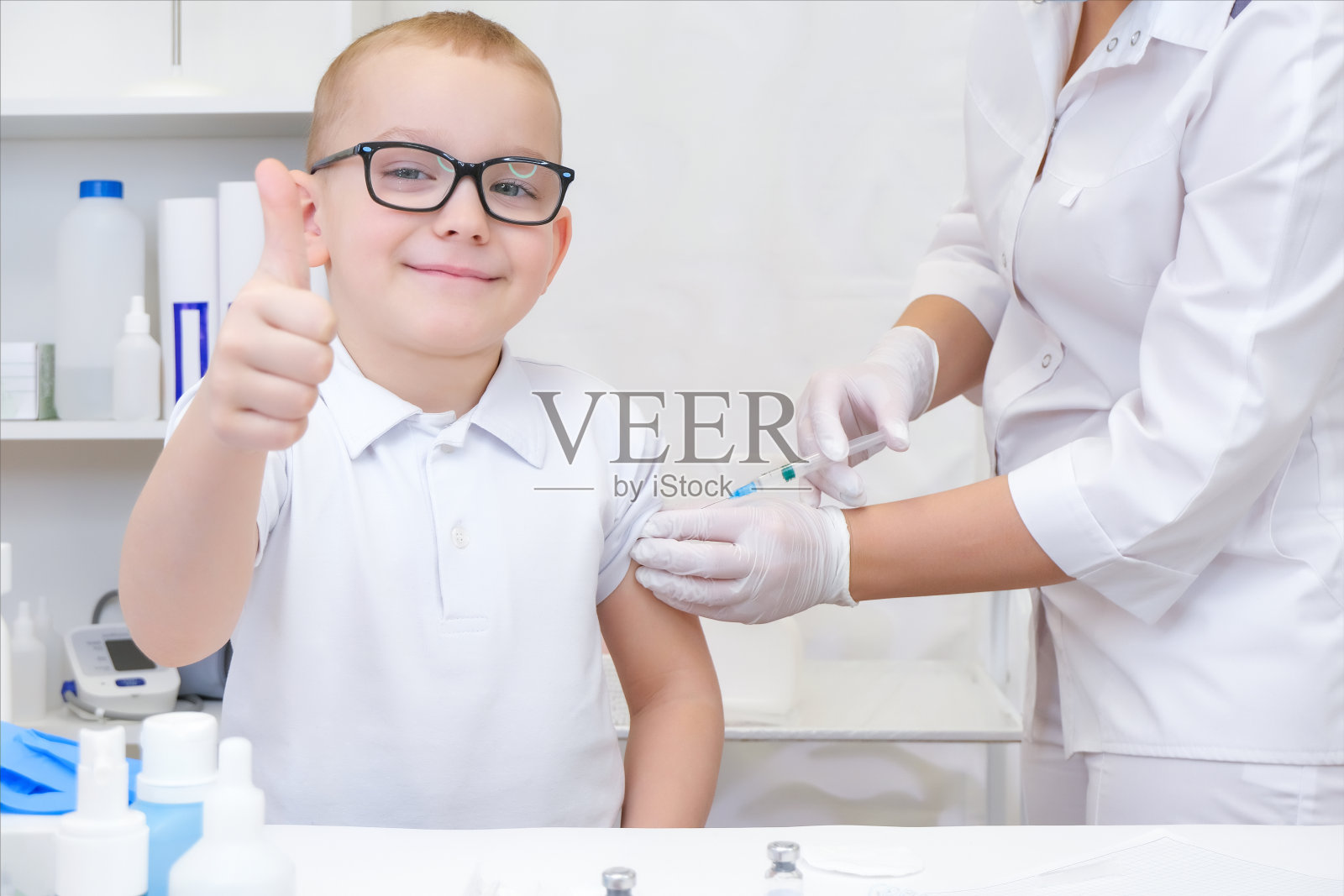 在诊所里接种疫苗的小男孩，请关门照片摄影图片