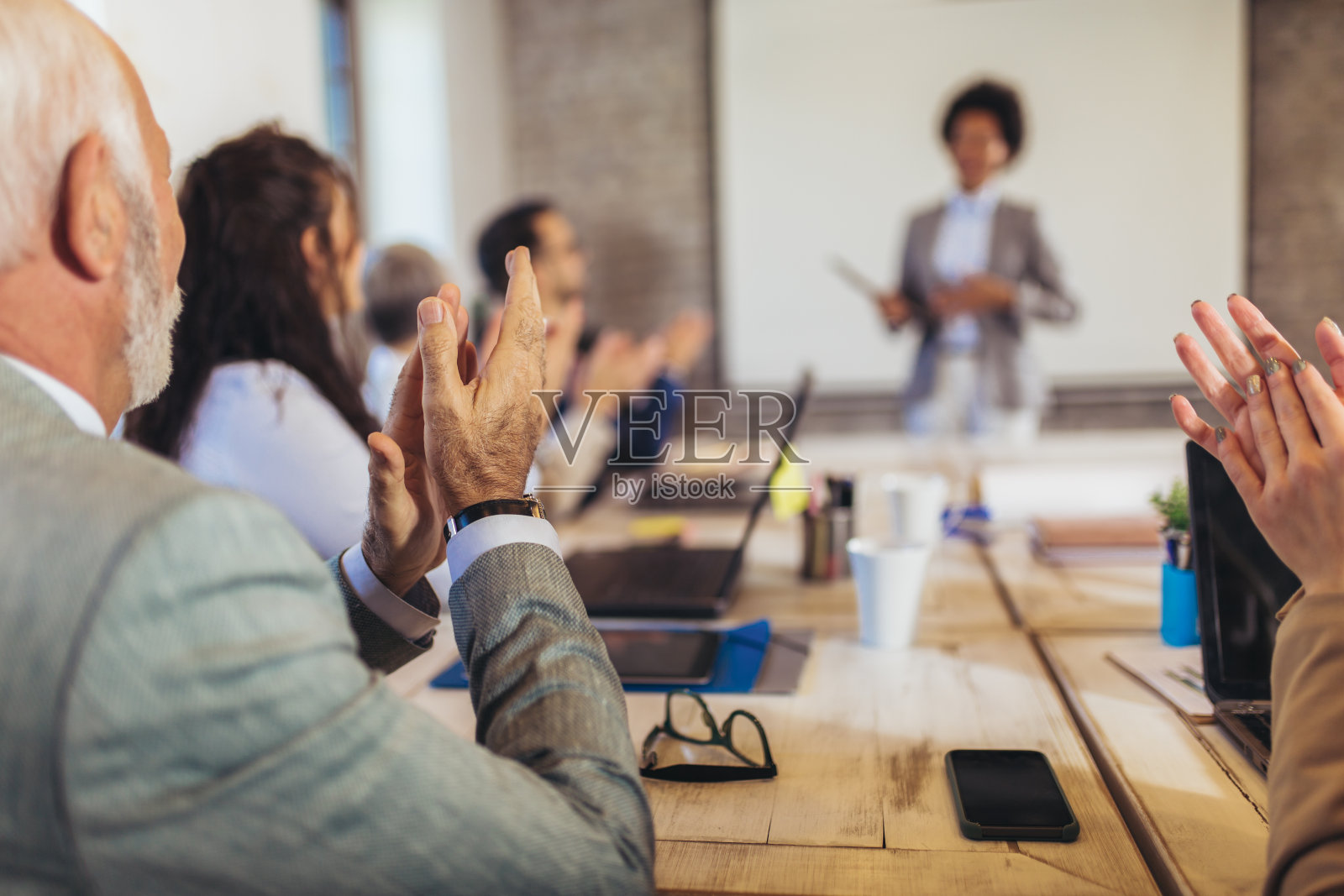 在办公室参加商务会议时，同事们开心地鼓掌。照片摄影图片