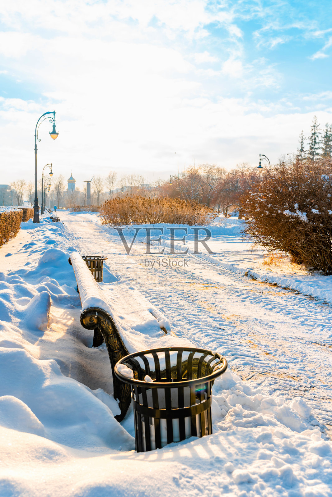 俄罗斯的Togliatti，冬日阳光明媚的城市步行街上，积雪覆盖的长椅。美丽的冬天的风景照片摄影图片