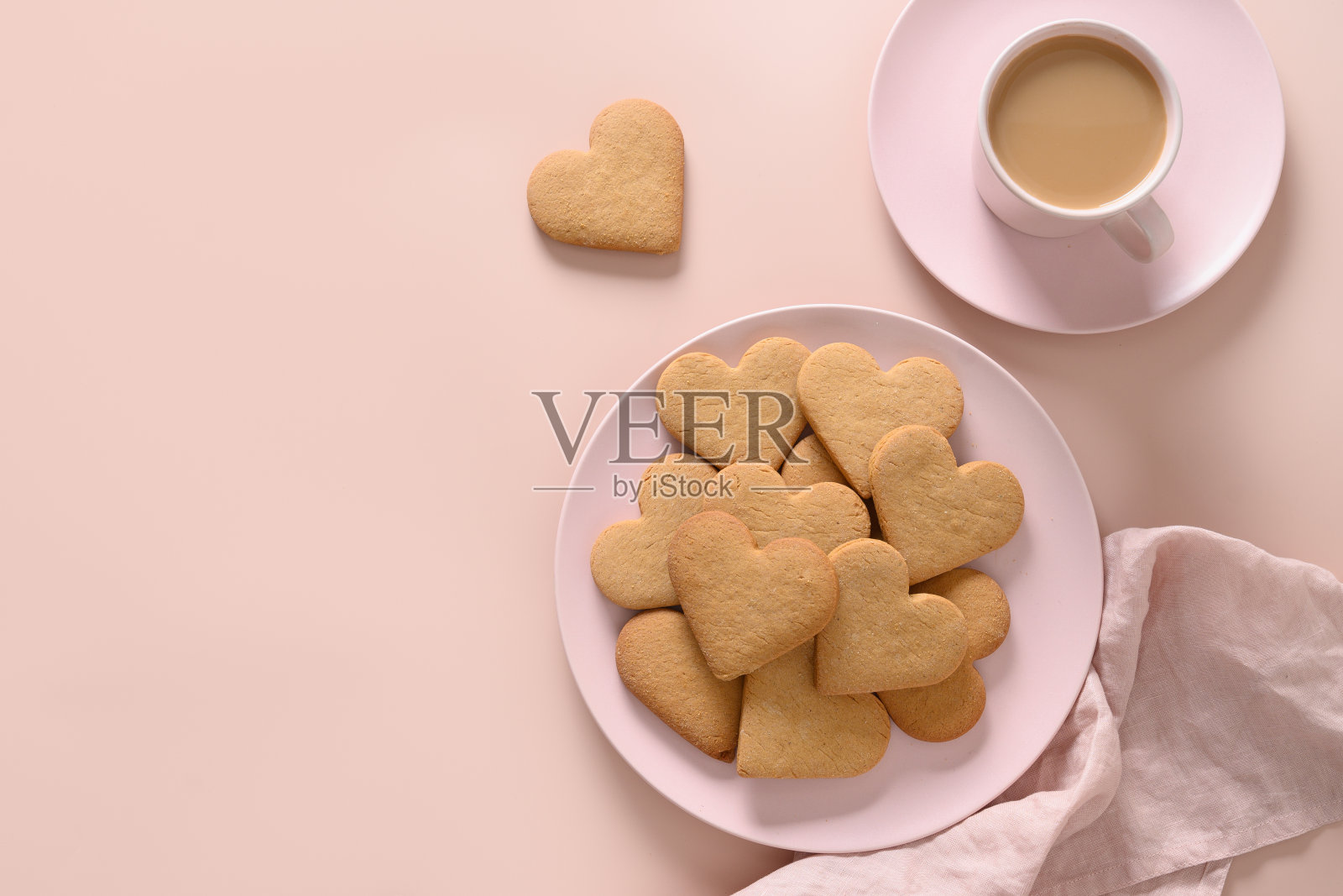 情人节牛奶咖啡，粉色盘子上心形饼干。照片摄影图片