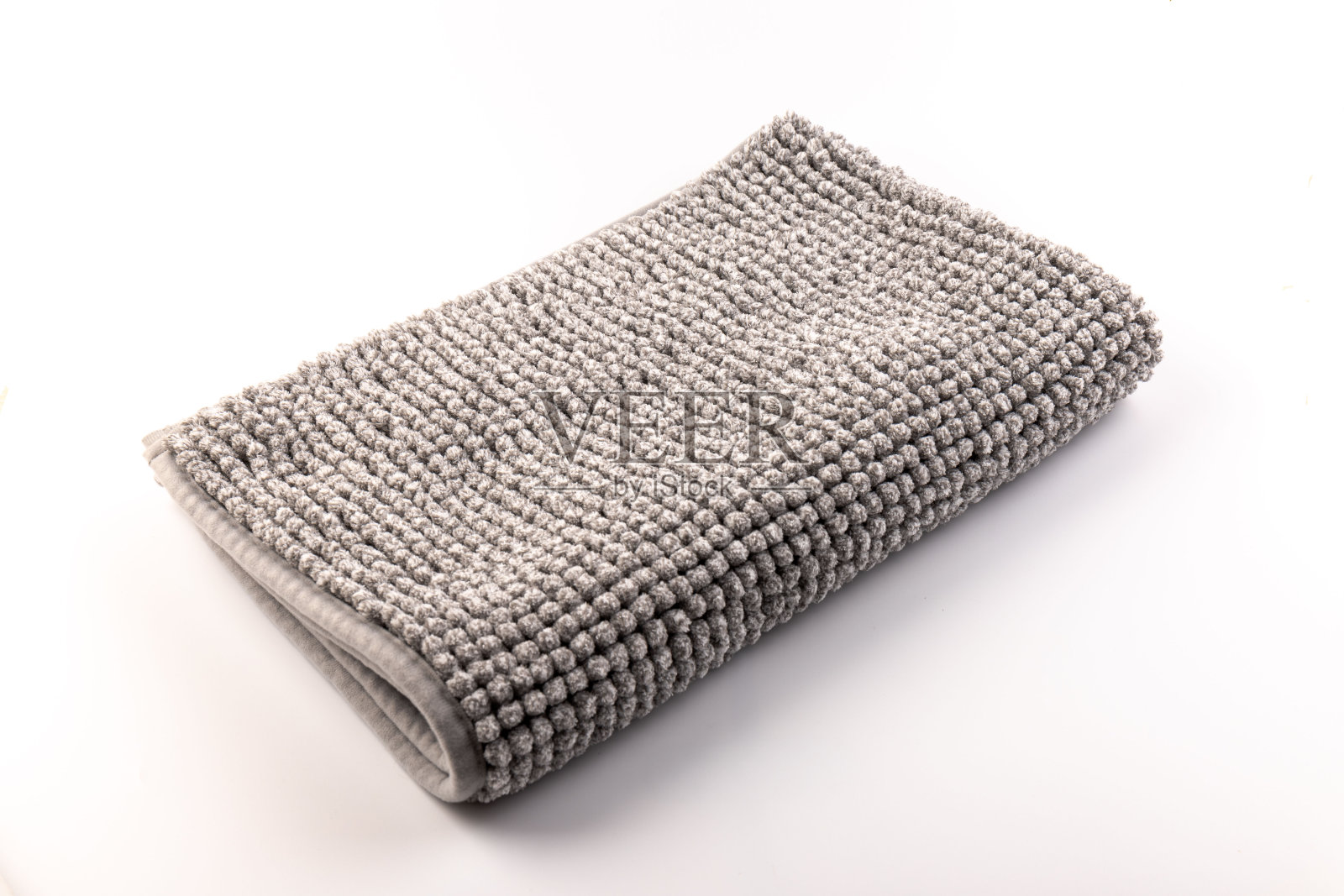 软灰色浴垫对白色背景，特写。浴室配件。前视图。照片摄影图片