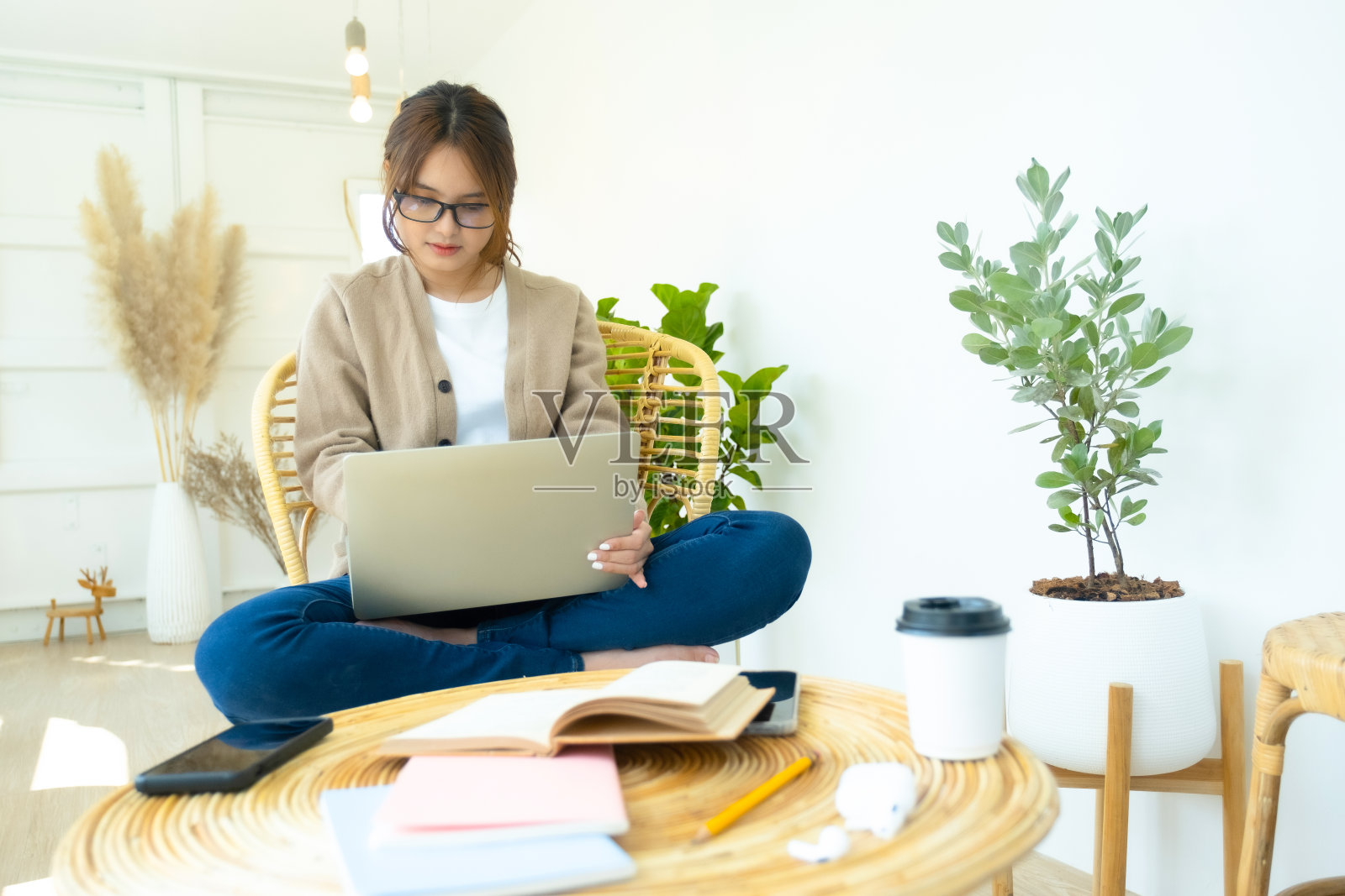 年轻的大学生使用电脑和移动设备在线学习。照片摄影图片