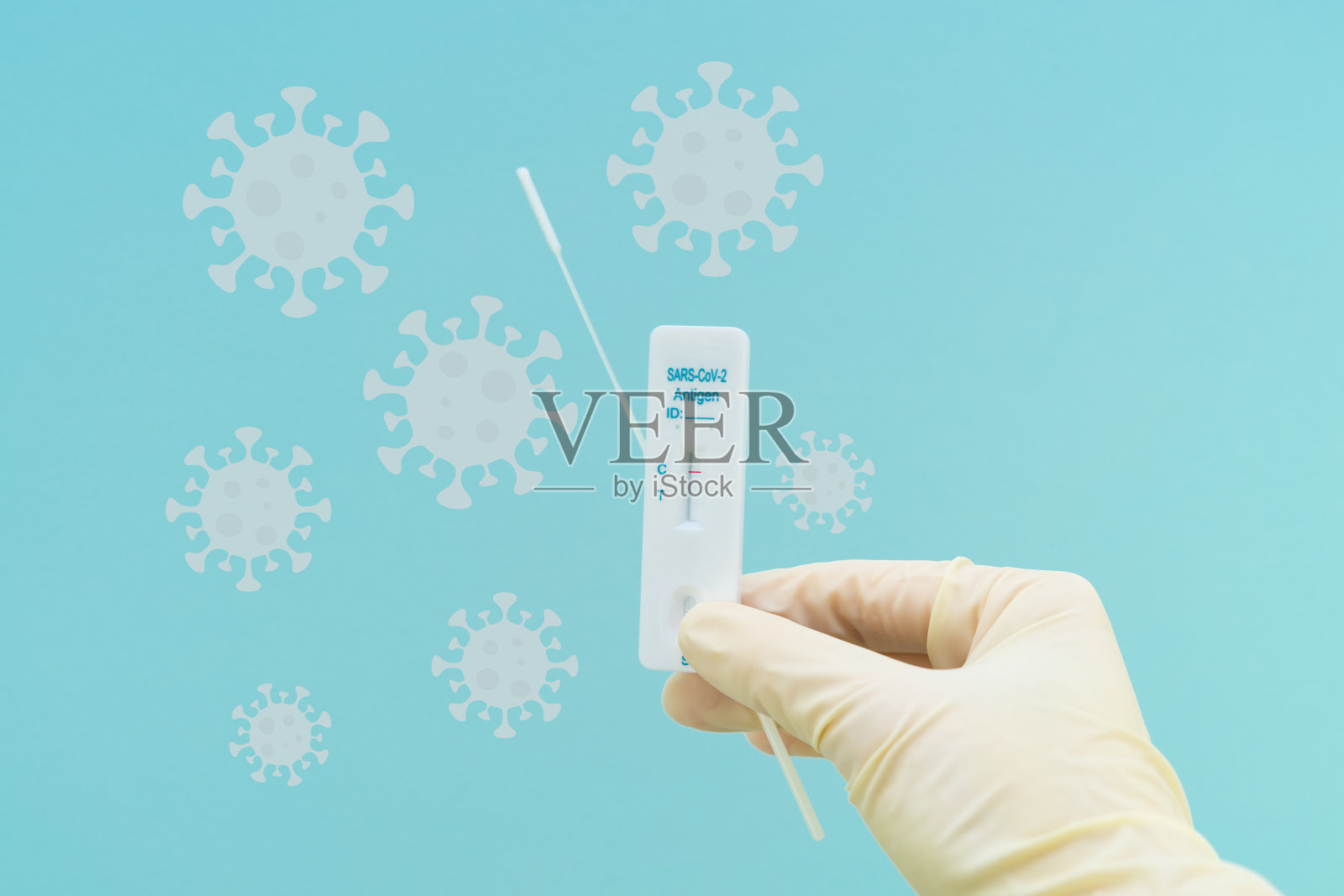 手拿抗原测试，蓝色背景上有病毒。概念pandemic covid 19。照片摄影图片