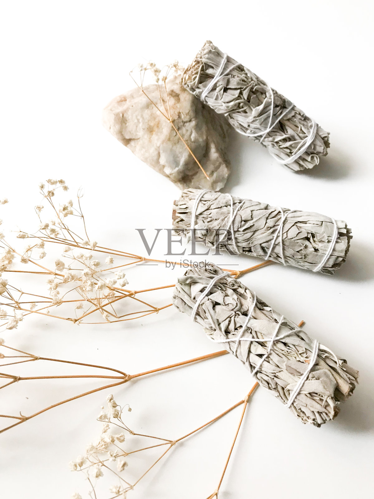 捆绑干白鼠尾草特写。产品净化，冥想和治疗。一套熏香，用于房屋的熏蒸。白色背景上的白鼠尾草枝。从以上观点。照片摄影图片