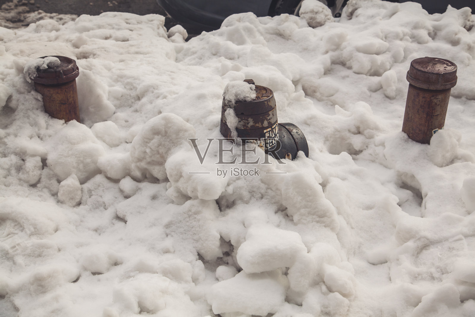 黑色的消防栓埋在雪堆里，在恶劣的天气:降雪和暴风雪照片摄影图片