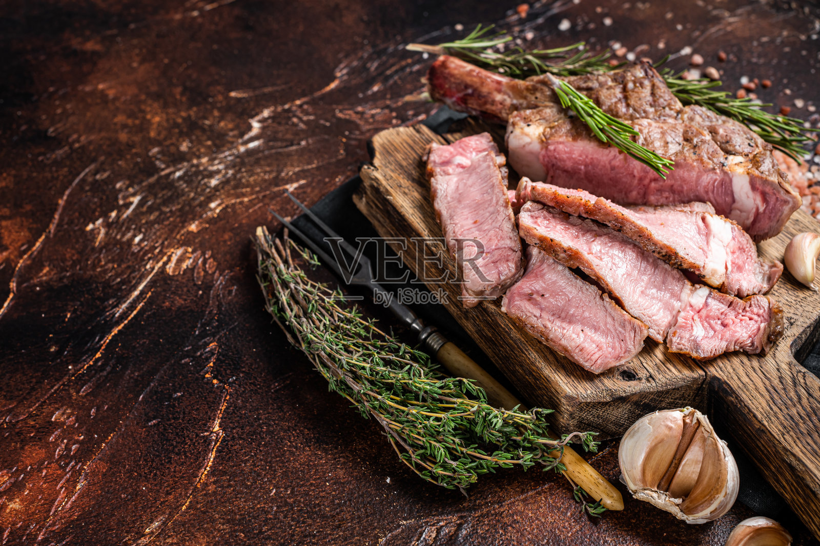 烧烤烤战斧牛排，肋眼在木板上。黑暗的背景。前视图。本空间照片摄影图片