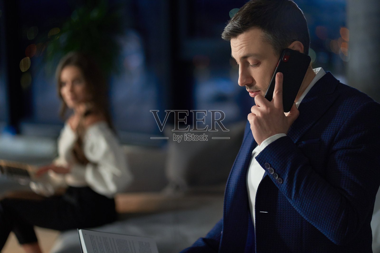 男人在打电话，女人在家里用笔记本电脑工作照片摄影图片