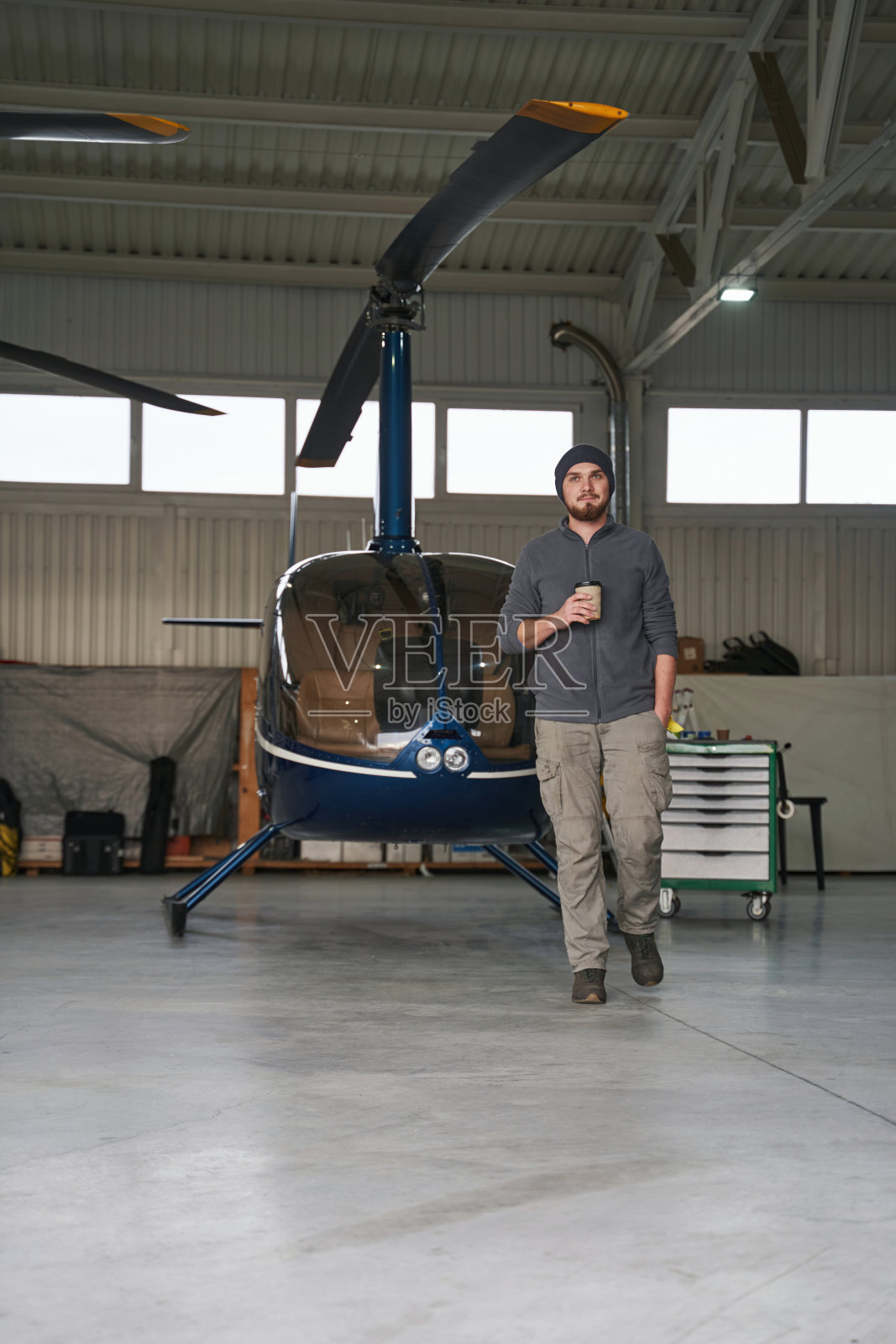 车库直升机前有个大胡子男人照片摄影图片