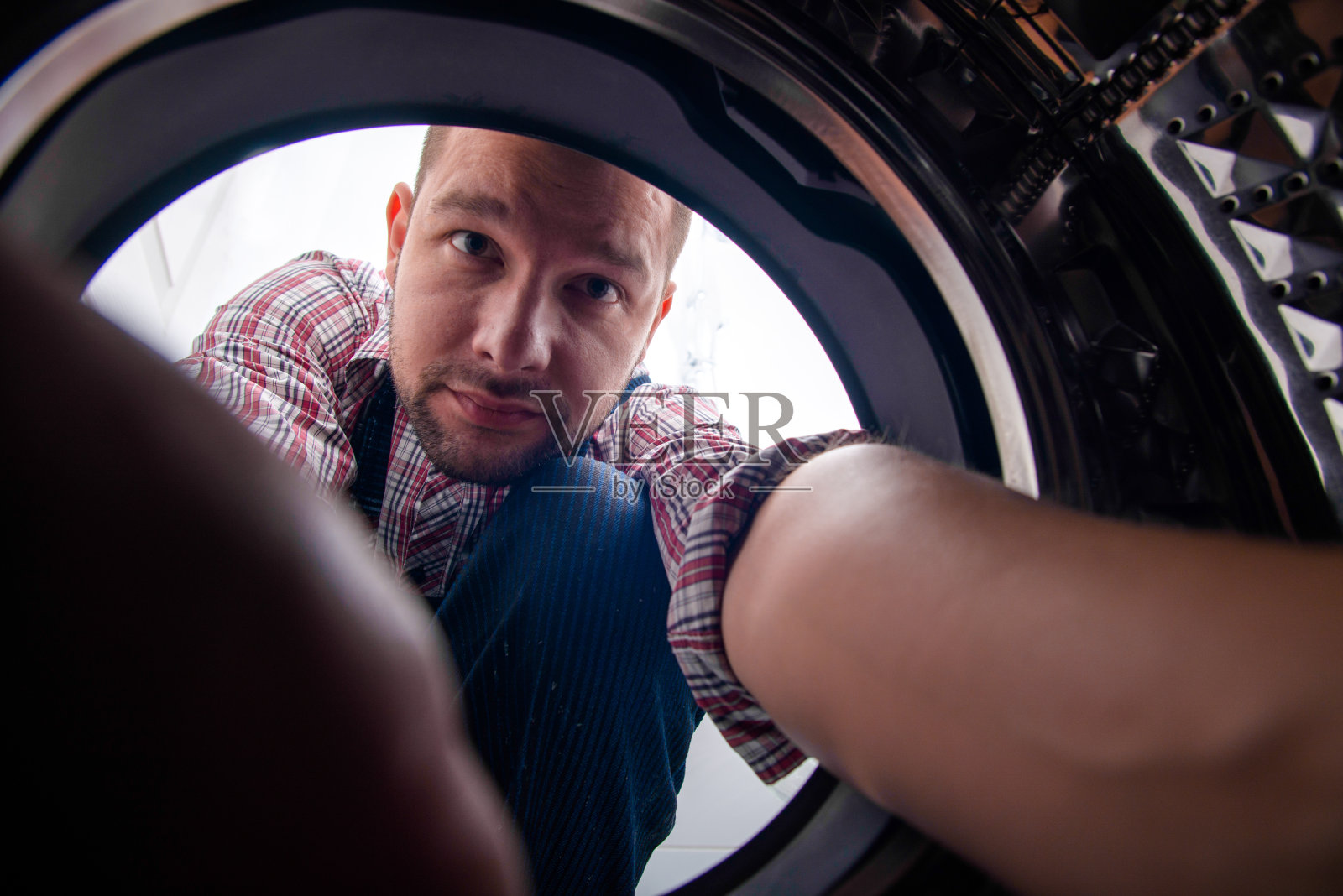 在浴室修洗衣机的制服工照片摄影图片
