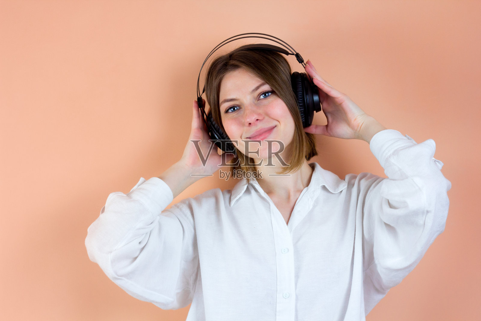 轻松的年轻女子喜欢在无线耳机听音乐，放松的冥想。有声读物照片摄影图片