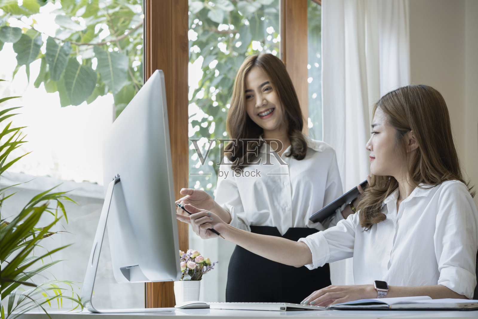 年轻的企业家们在明亮的办公室里讨论商业战略。照片摄影图片