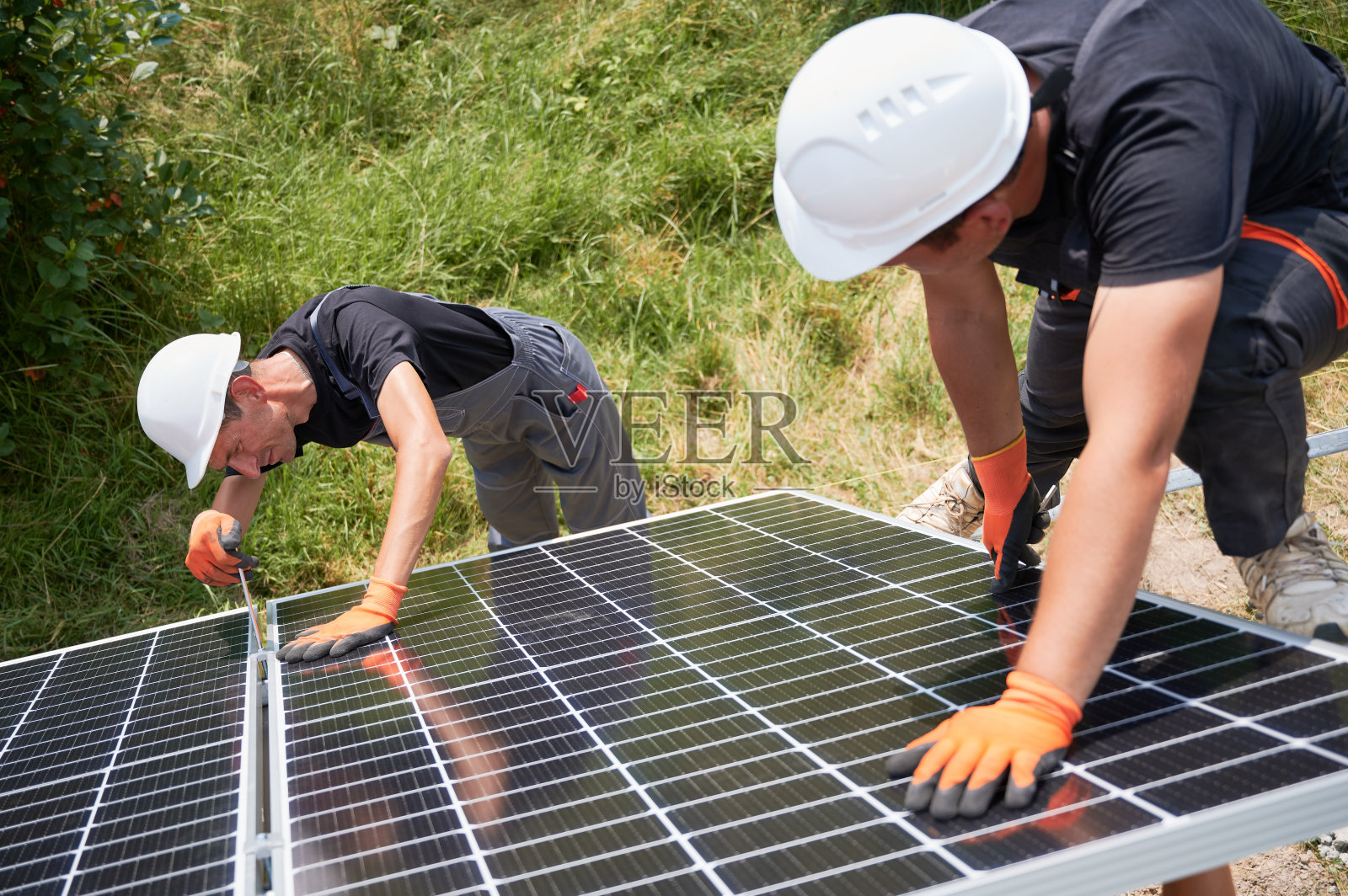安装光伏太阳能电池板系统的工人。照片摄影图片