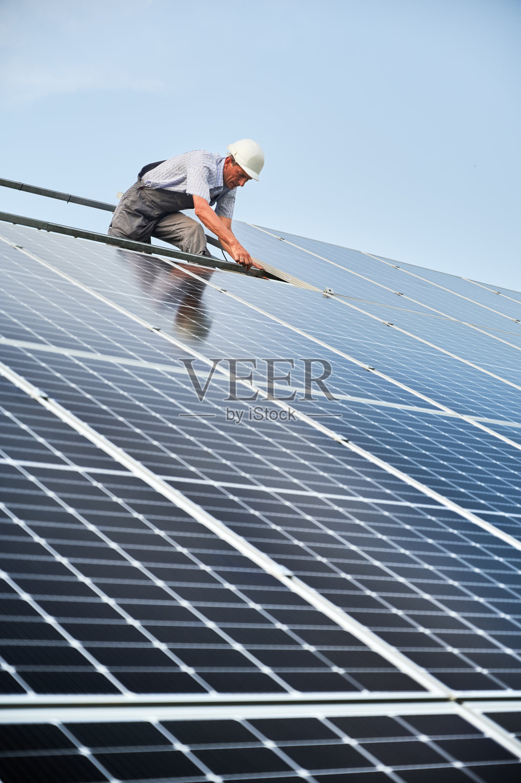 安装光伏太阳能电池板系统的工人照片摄影图片