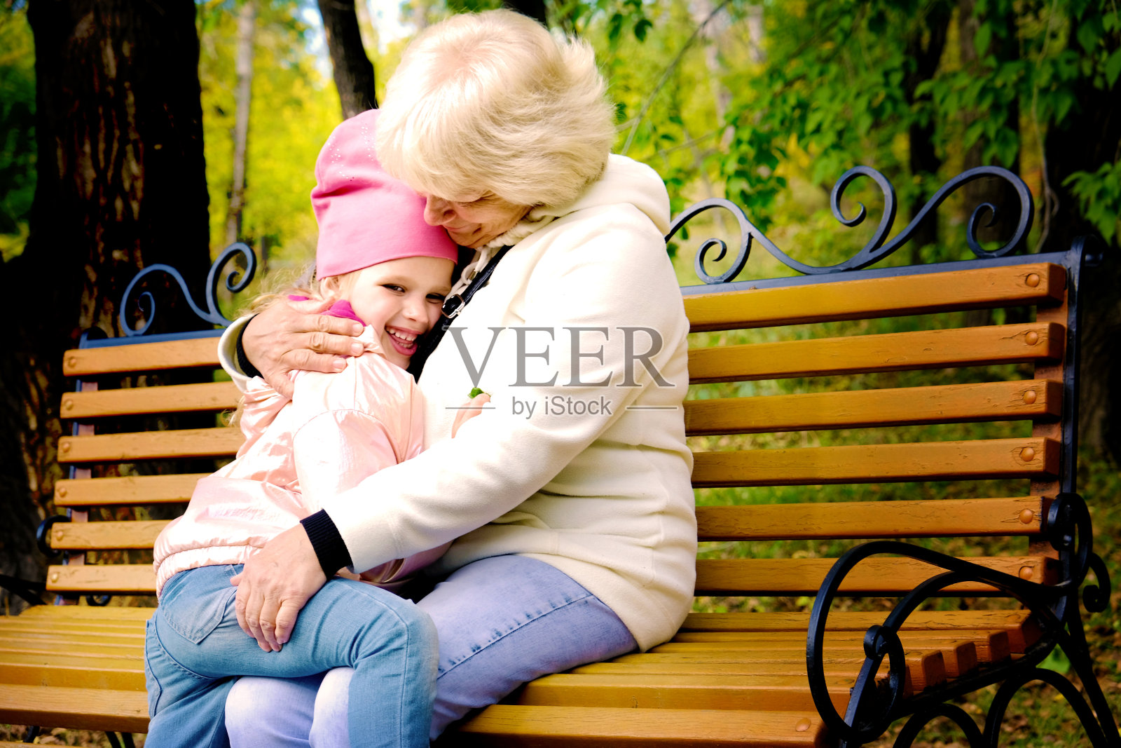 祖母和孙女在公园长椅上拥抱交谈照片摄影图片