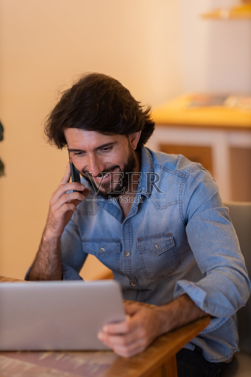 年轻的商人在家里工作，笔记本电脑和桌子上的文件。家庭办公室的概念。照片摄影图片