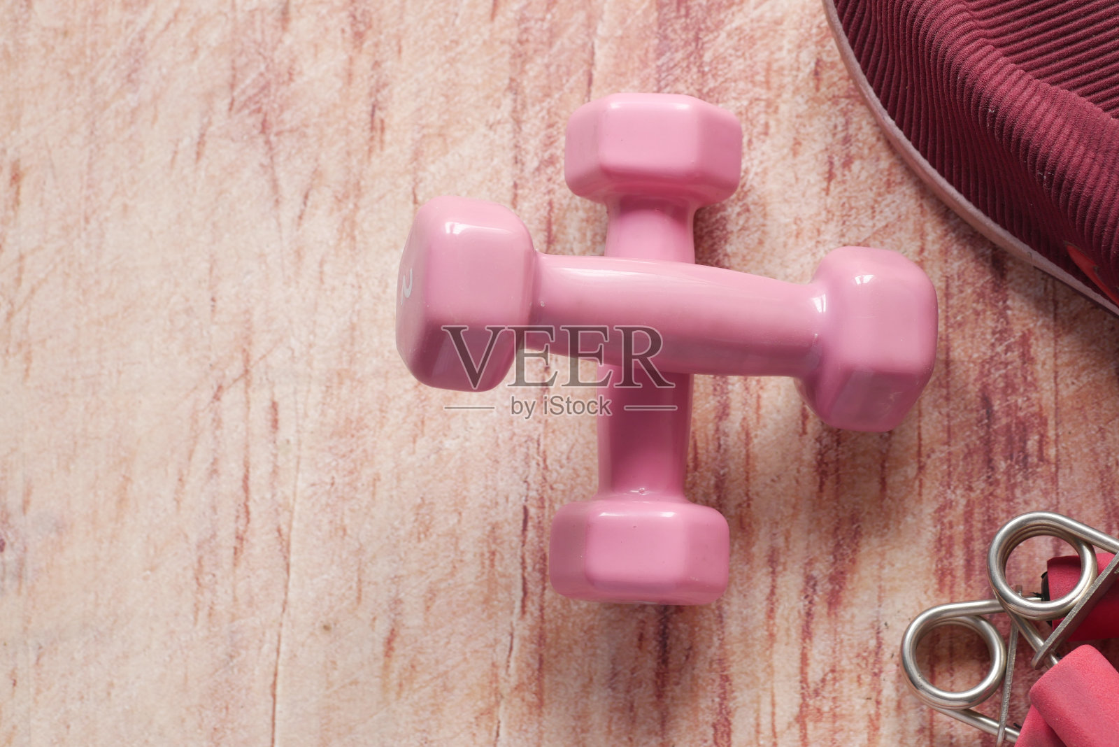 粉红色的哑铃，鞋和耳机在粉红色的背景照片摄影图片