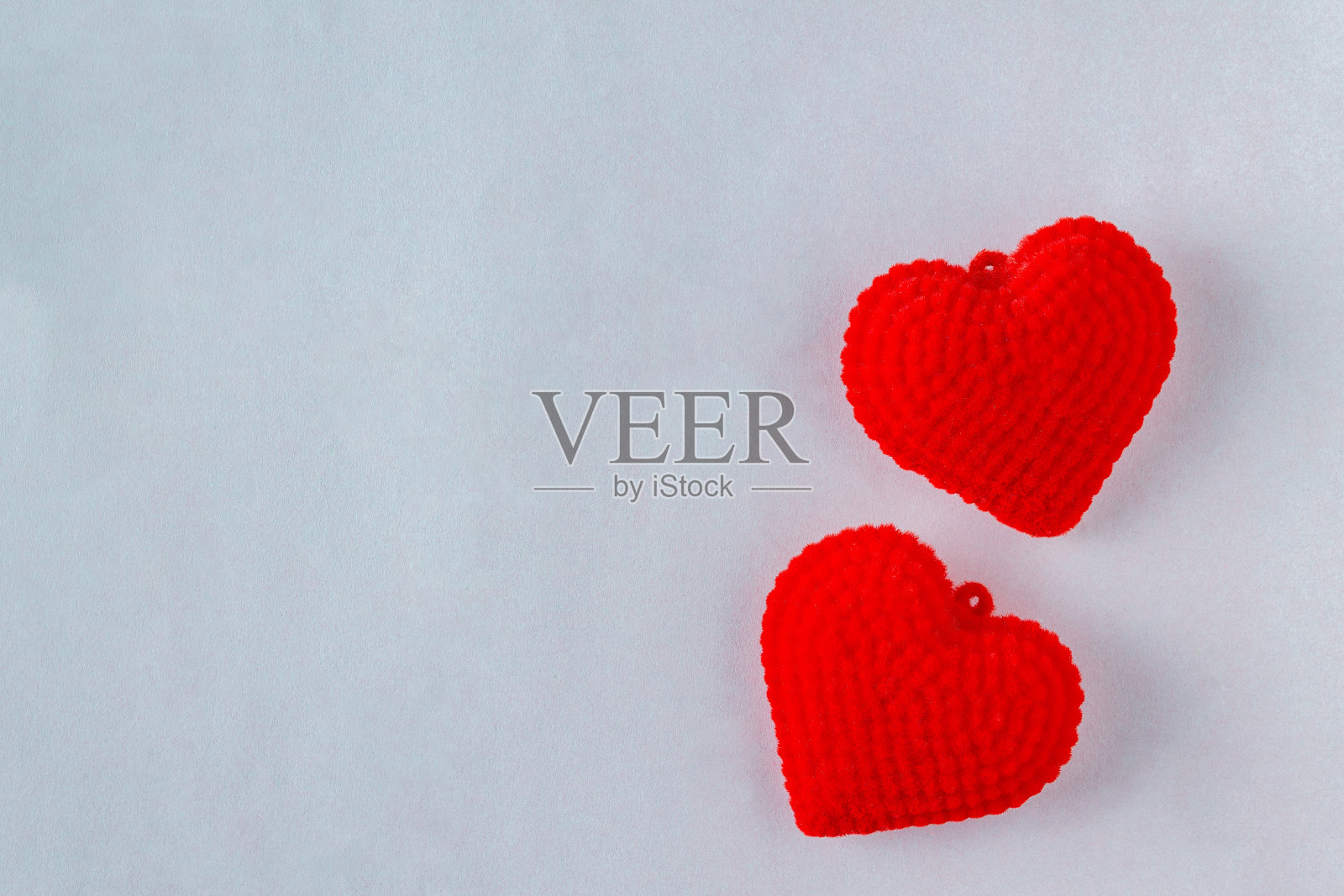 浅灰色背景上的红色毛绒心照片摄影图片