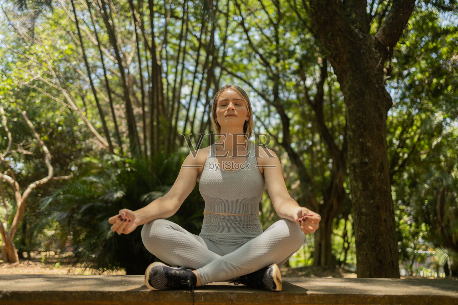 年轻人沉思。在阳光下练习瑜伽和冥想。在公园的一天。高质量的照片。照片摄影图片