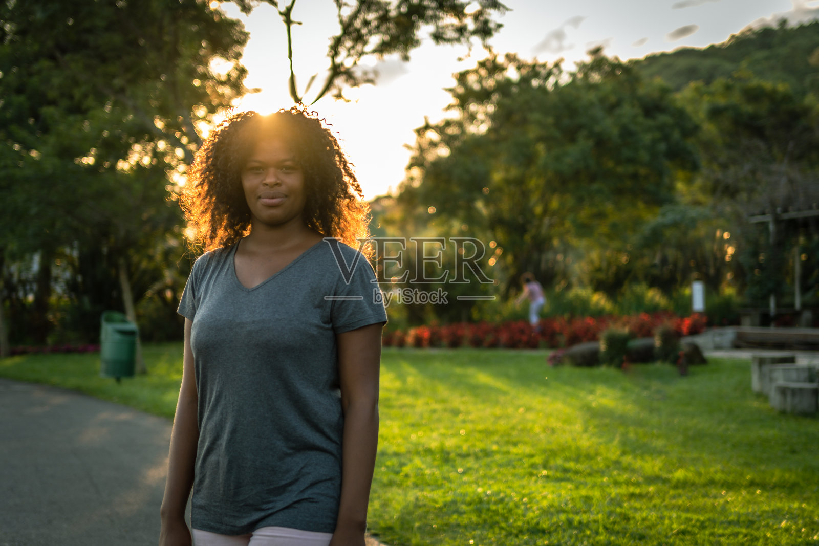 在阳光的照耀下，一个卷发的女人微笑着照片摄影图片