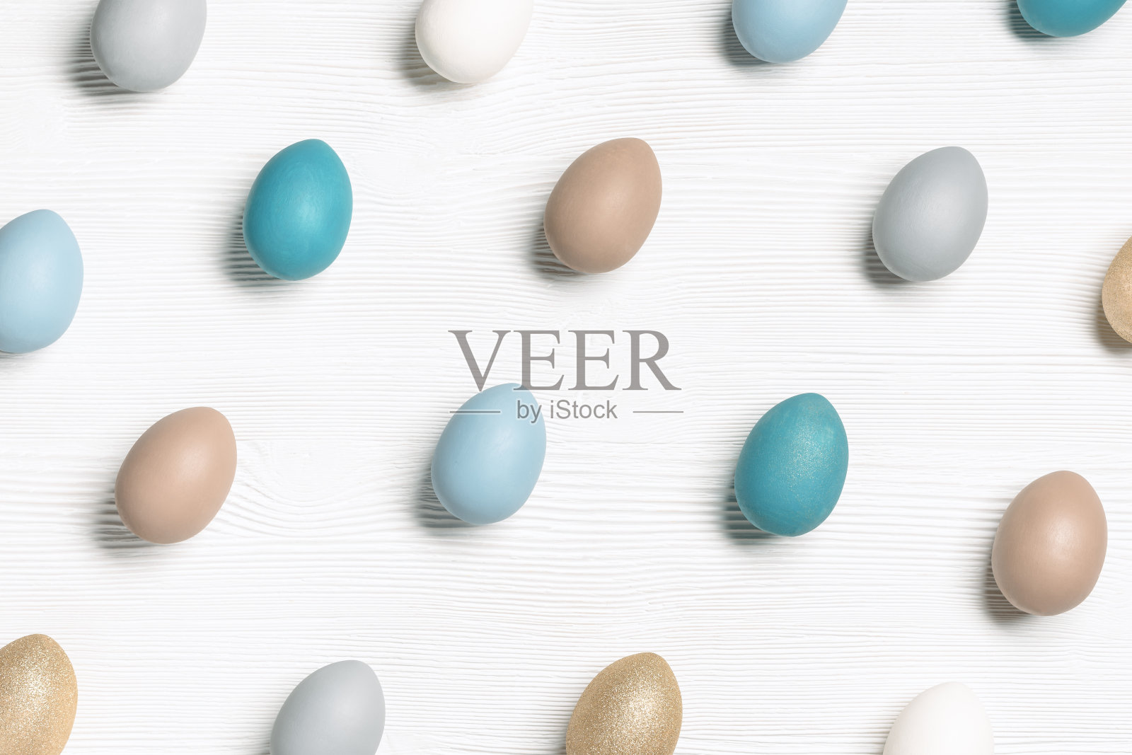 染色彩色复活节蛋蓝色，米色，中性色，节日鸡蛋作为图案在白色木材背景。节日食品，象征复活节，简约风格美学布局，几何设计照片摄影图片
