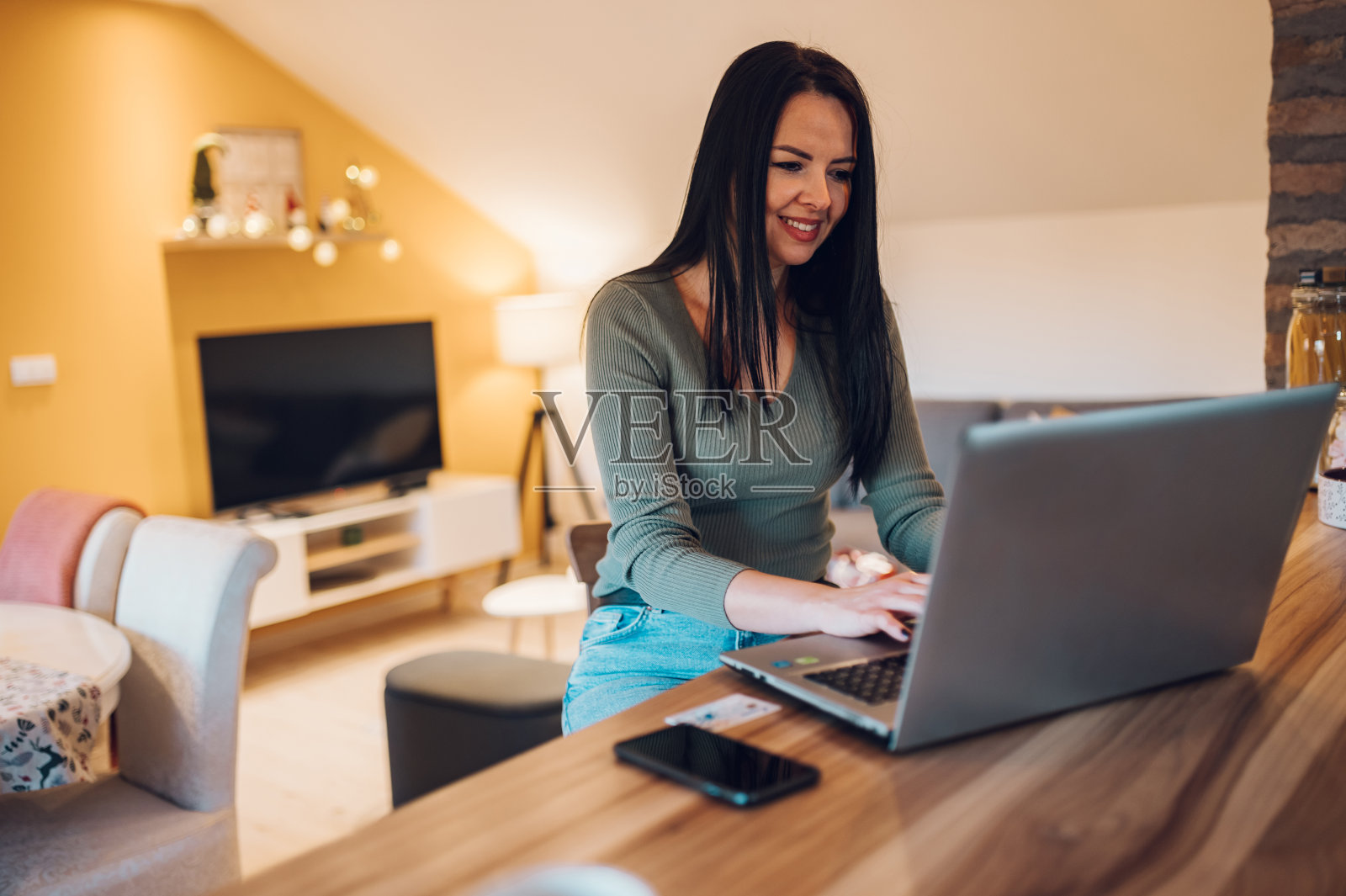 中年妇女在家使用笔记本电脑。照片摄影图片