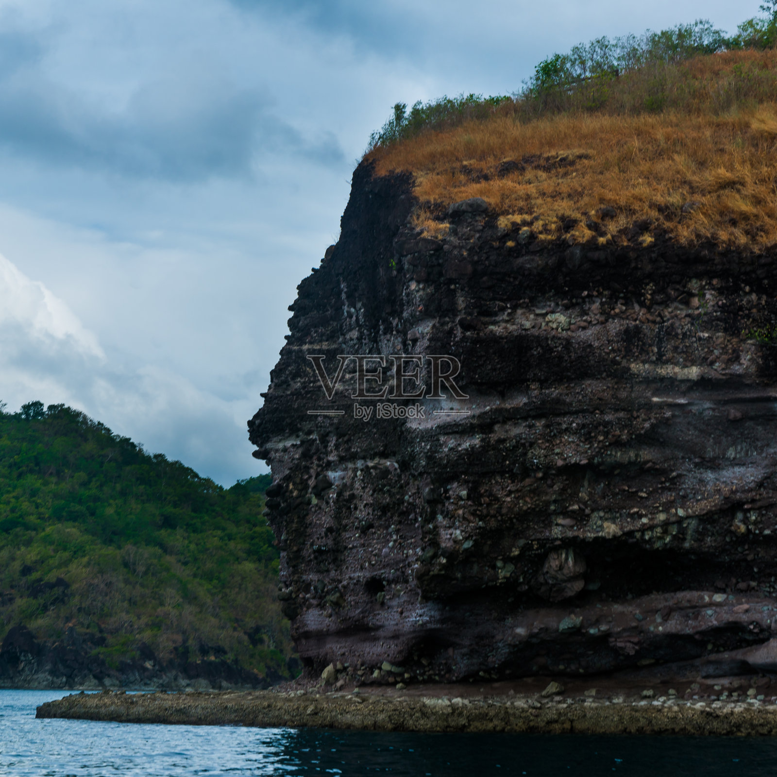 岩石岛在美丽的蓝色海水之上。照片摄影图片