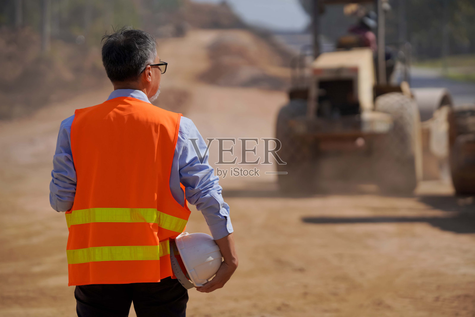 亚洲工程师或投资者和工人在“道路建设工地用挖掘机和压路机进行道路建设工程”照片摄影图片
