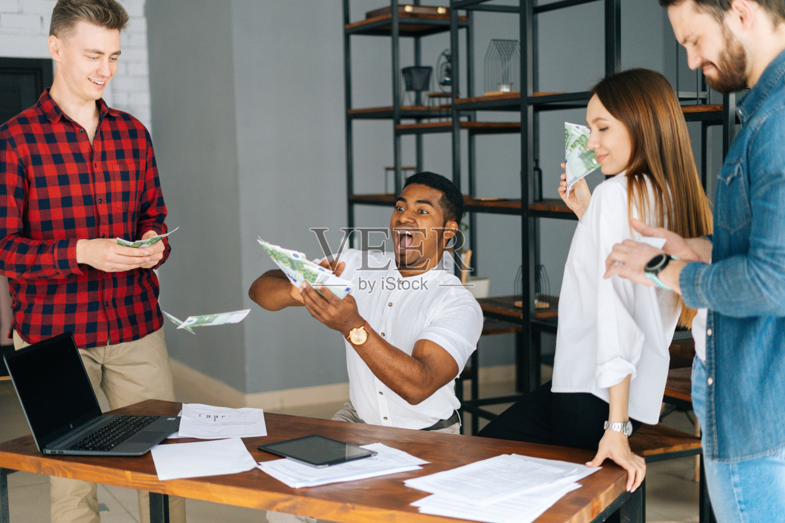 快乐的商业团队，年轻的多民族员工庆祝胜利和巨大的利润。照片摄影图片