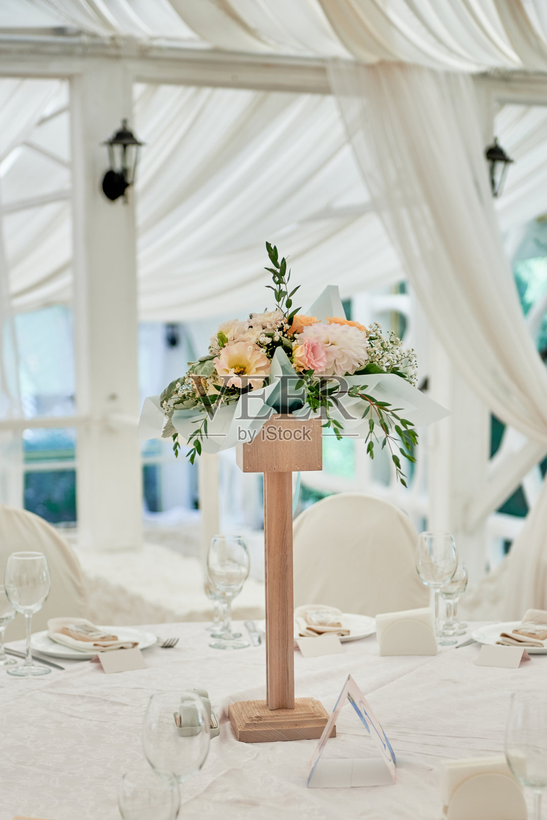 美丽的花卉安排玫瑰和绿色植物在婚礼桌上的餐厅，复制空间。豪华婚礼装饰。表设置照片摄影图片