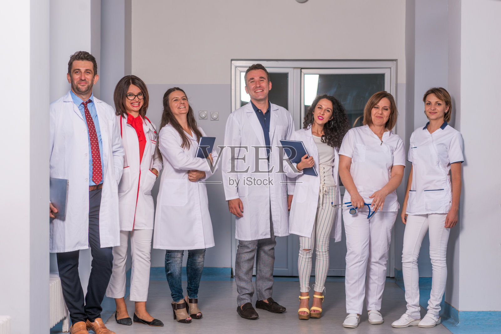 一群医务人员、队医和护士在医院、诊所的走廊里摆姿势。照片摄影图片