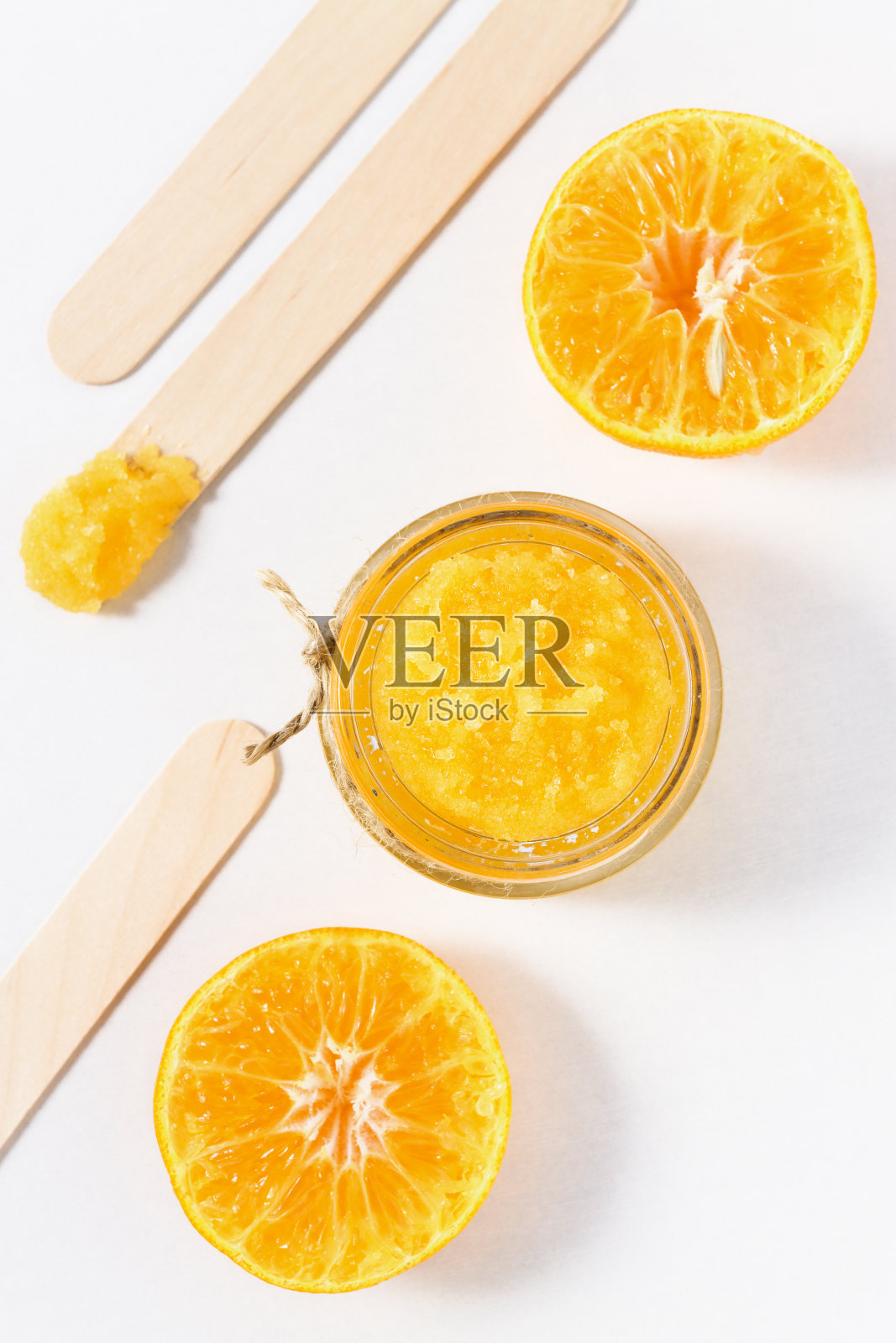 橙色糖磨砂白色木制背景，俯视图。自制美容产品配橙片。照片摄影图片