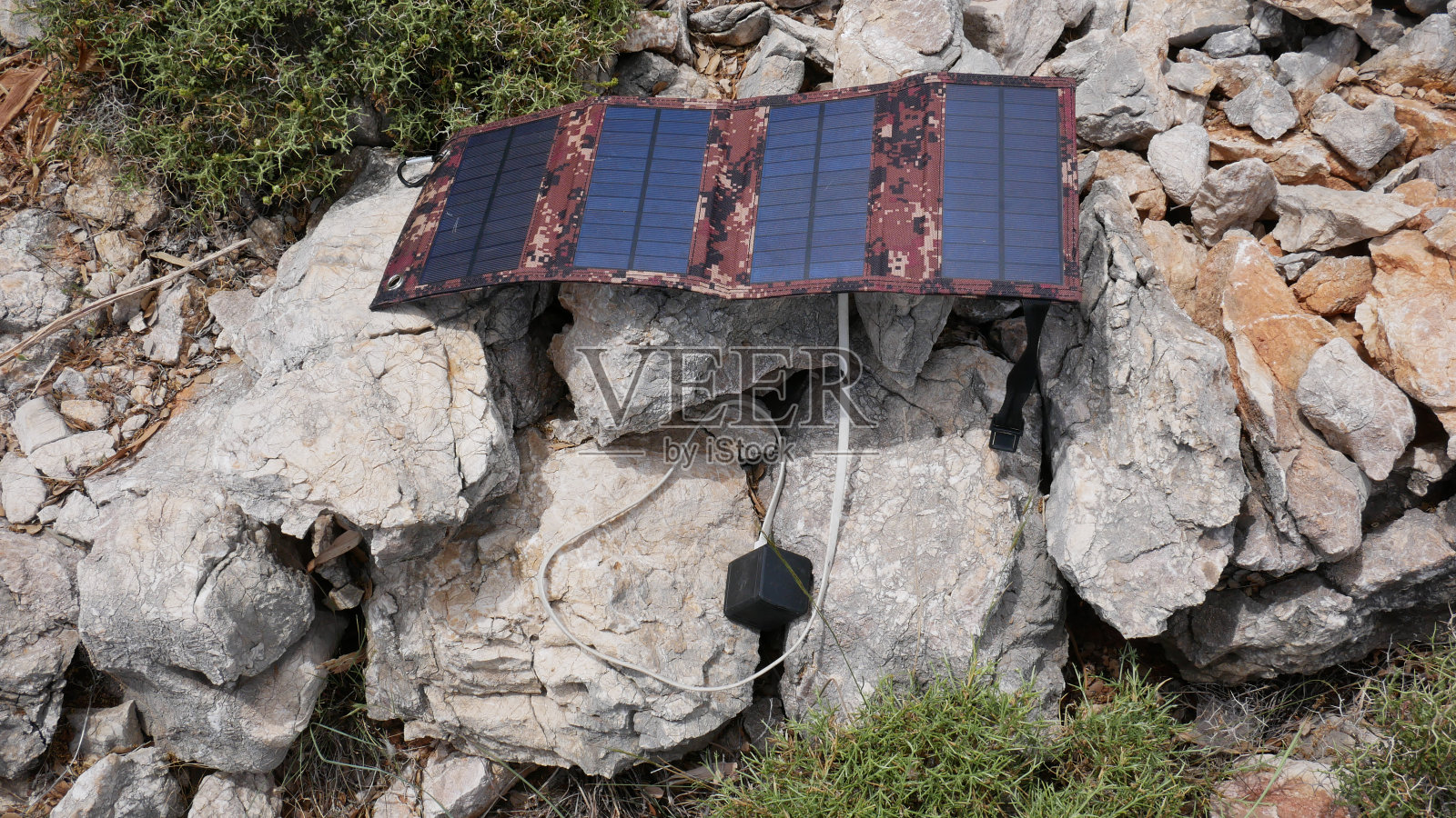 太阳能电池板给岩石上的电池充电。照片摄影图片