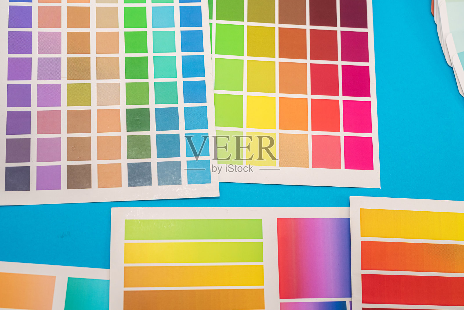 印刷在调色板上的方块颜色样本位于蓝色背景上照片摄影图片