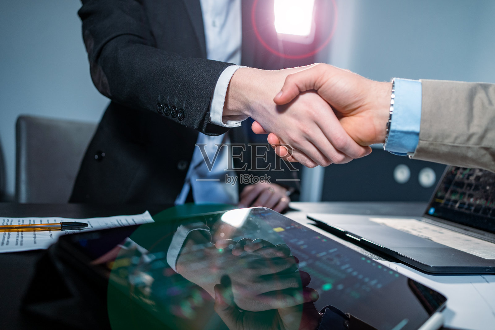 商务人士在办公室用电脑握手照片摄影图片