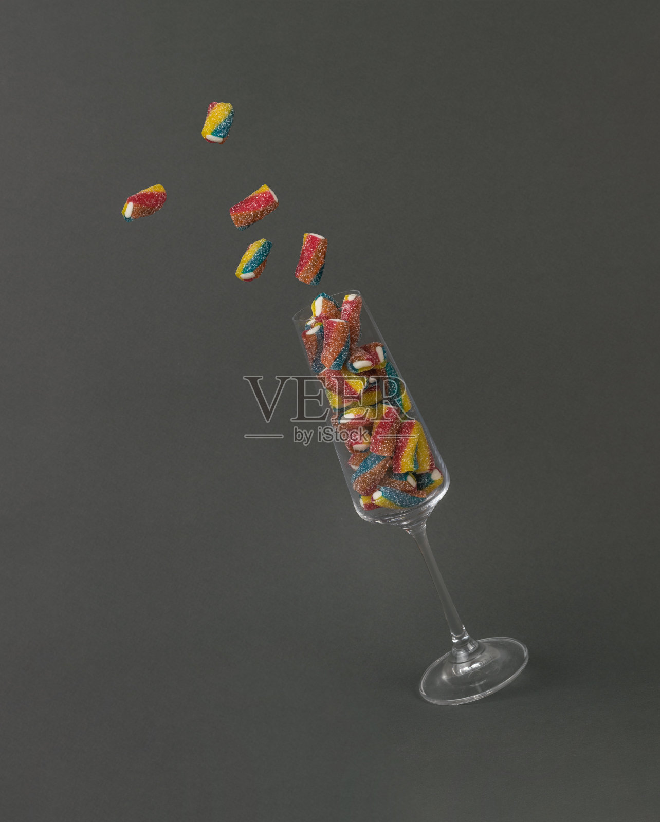 一小片橘子酱从掉下来的玻璃杯里飞了出来。照片摄影图片