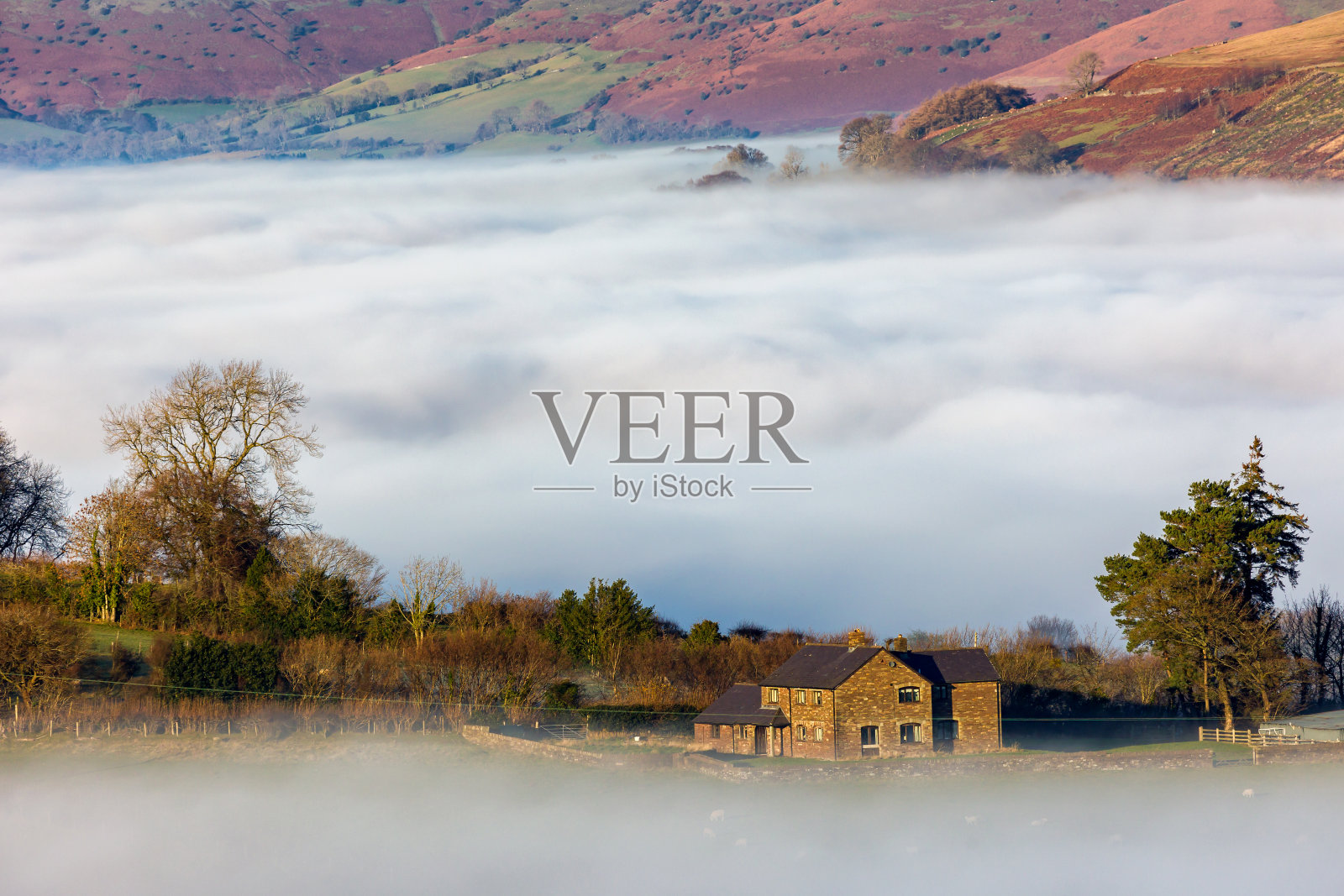 位于威尔士布雷肯信标的低空雾和云逆温上空的农田照片摄影图片