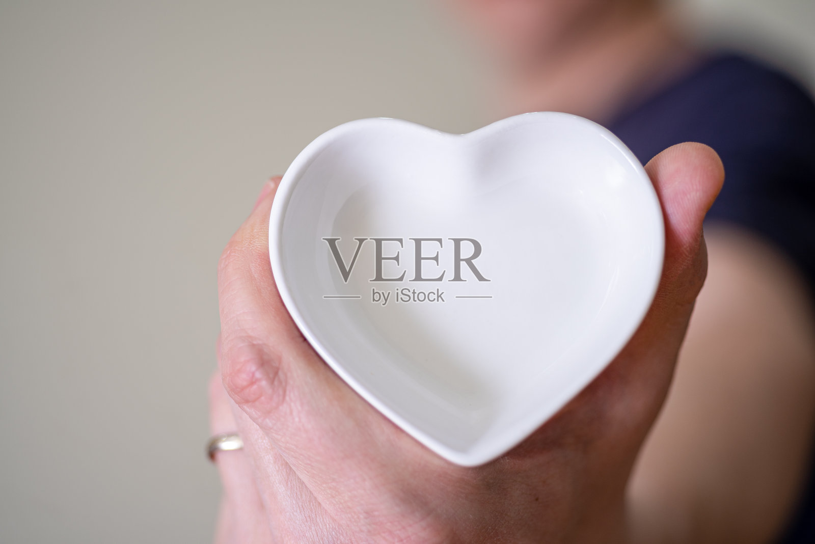 一个男人拿着一个心形碟子的特写镜头。照片摄影图片