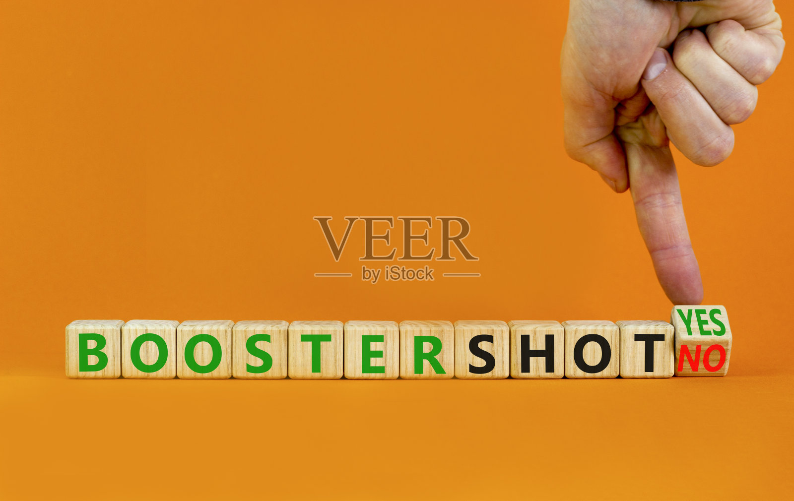 新冠肺炎增强疫苗注射是或否标志。医生翻方块儿，换句话说助推器不是助推器是。漂亮的橙色背景复制空间。新冠肺炎强化疫苗注射概念。照片摄影图片