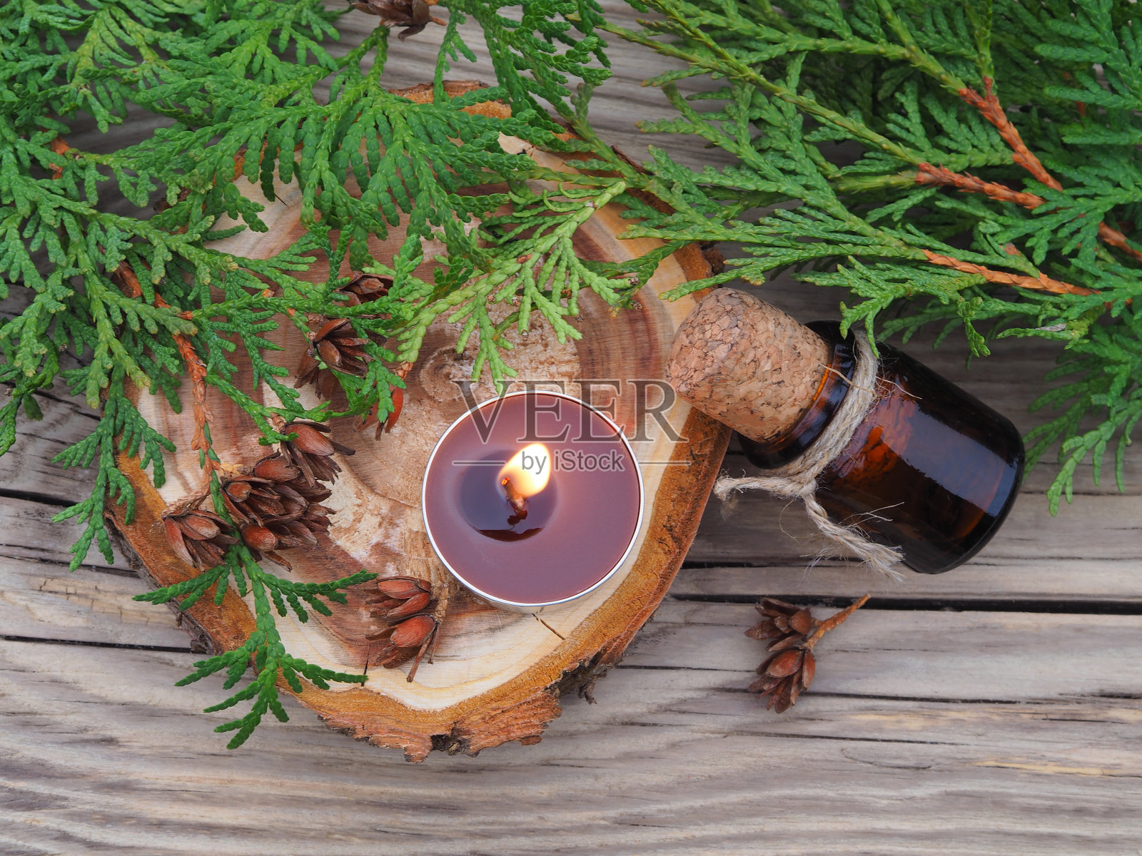 木桌上的香枝、草药油和燃烧的香味蜡烛，俯视图，平面布局。天然药用植物用于治疗，替代医学，顺势疗法和美容照片摄影图片