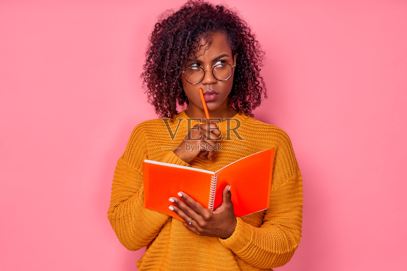 一名沉思的年轻非裔美国女学生手持笔记本和铅笔准备大学考试照片摄影图片