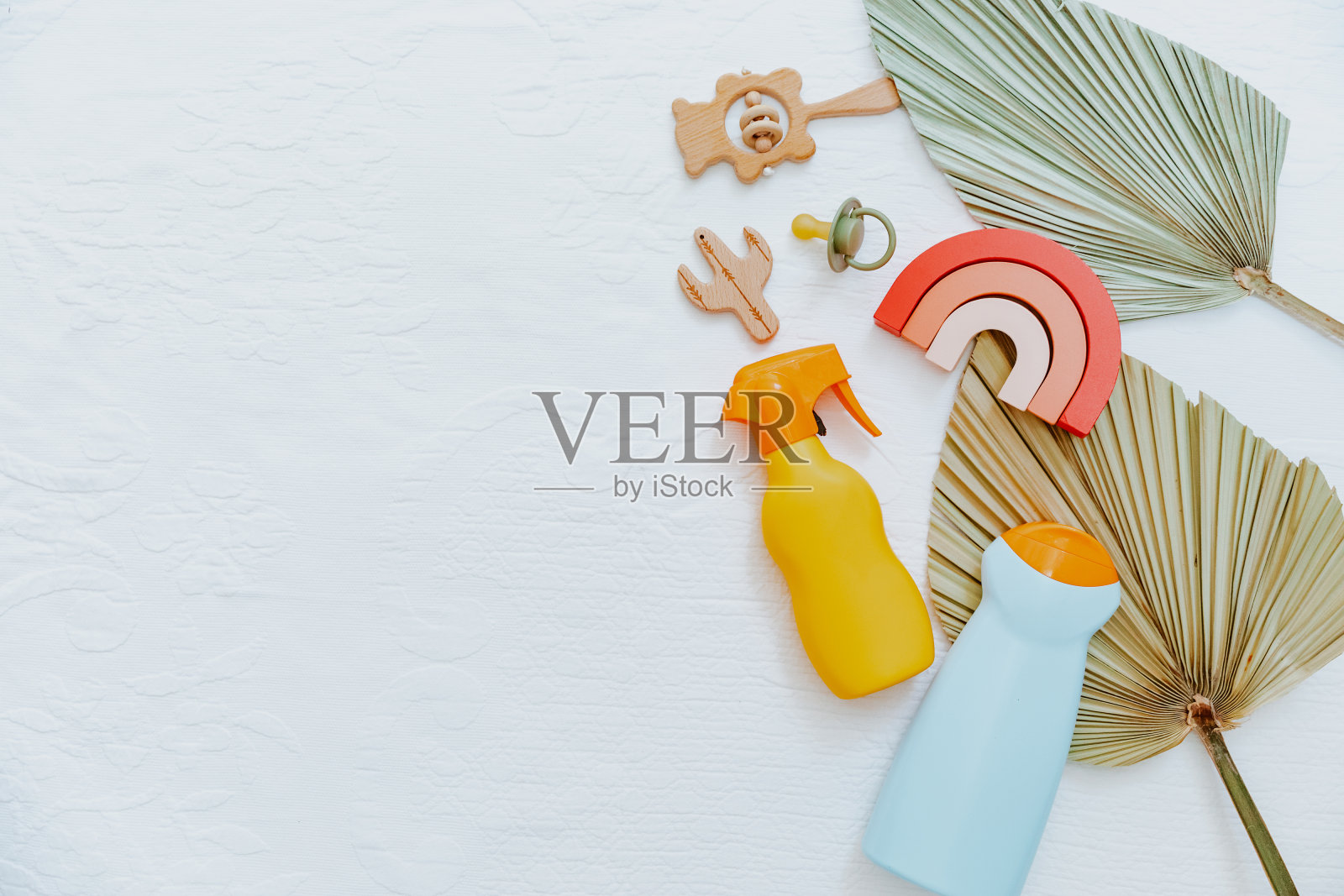 一瓶防晒霜，还有儿童玩具和沙滩用品。儿童护肤保护理念。平躺，俯视图照片摄影图片